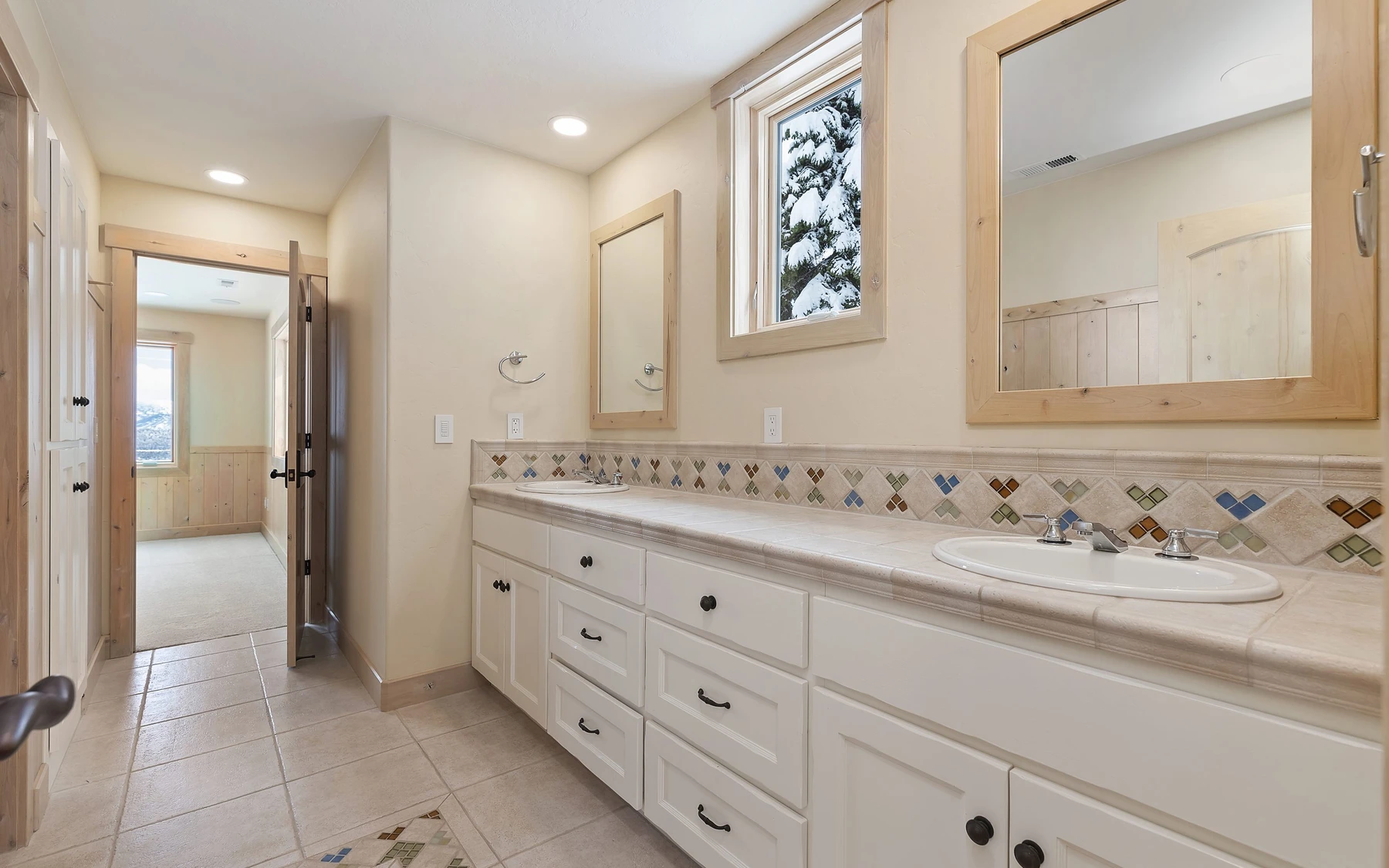 Bathroom in the Club Hill Refresh remodel at Whitetail Club, with a soaking tub, a custom vanity, and wood cabinetry.