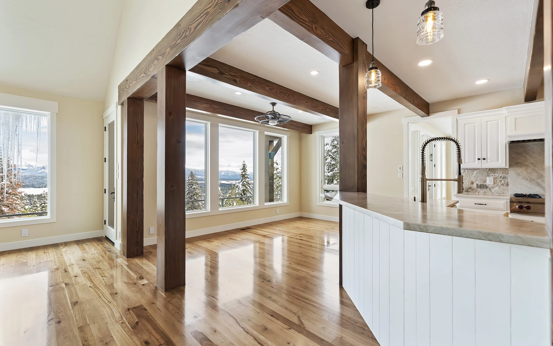 Kitchen in the Club Hill Refresh remodel at Whitetail Club, with wood cabinetry, a broad countertop, and pendant lighting.
