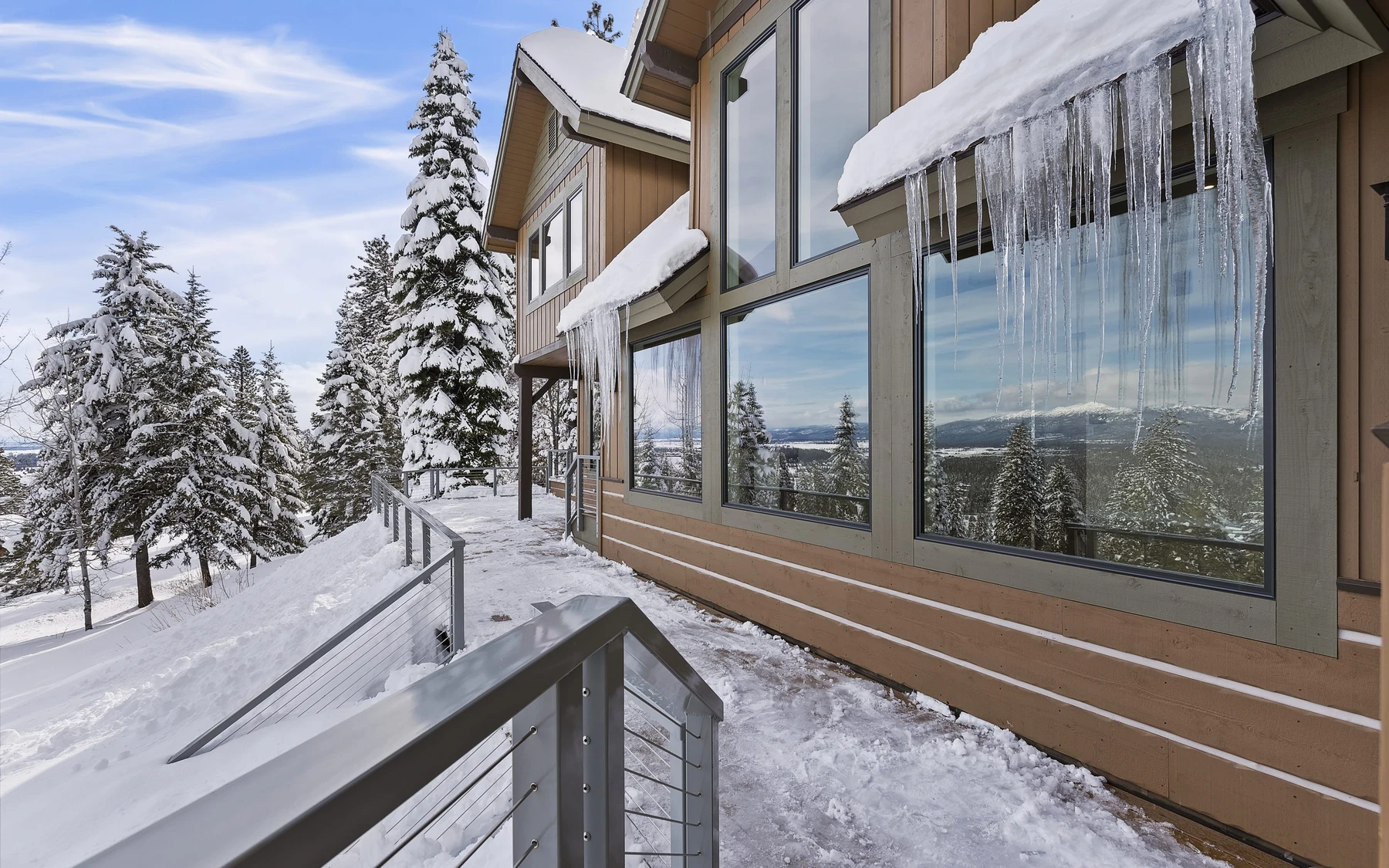 Exterior of the Club Hill Refresh remodel at Whitetail Club, showing wood siding and timber details, large windows, and the surrounding forest.
