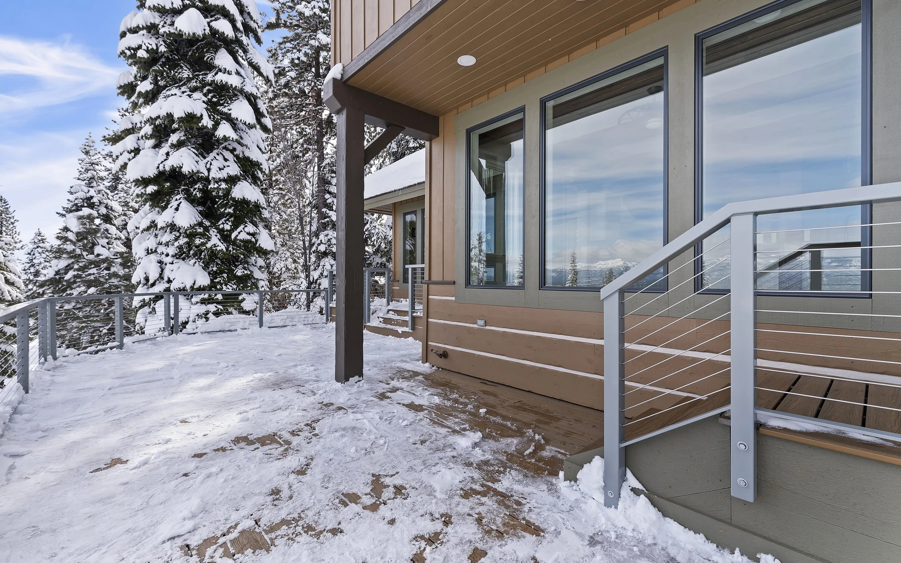 Covered outdoor space at the Club Hill Refresh remodel at Whitetail Club, with timber details, forest views, and a winter setting.