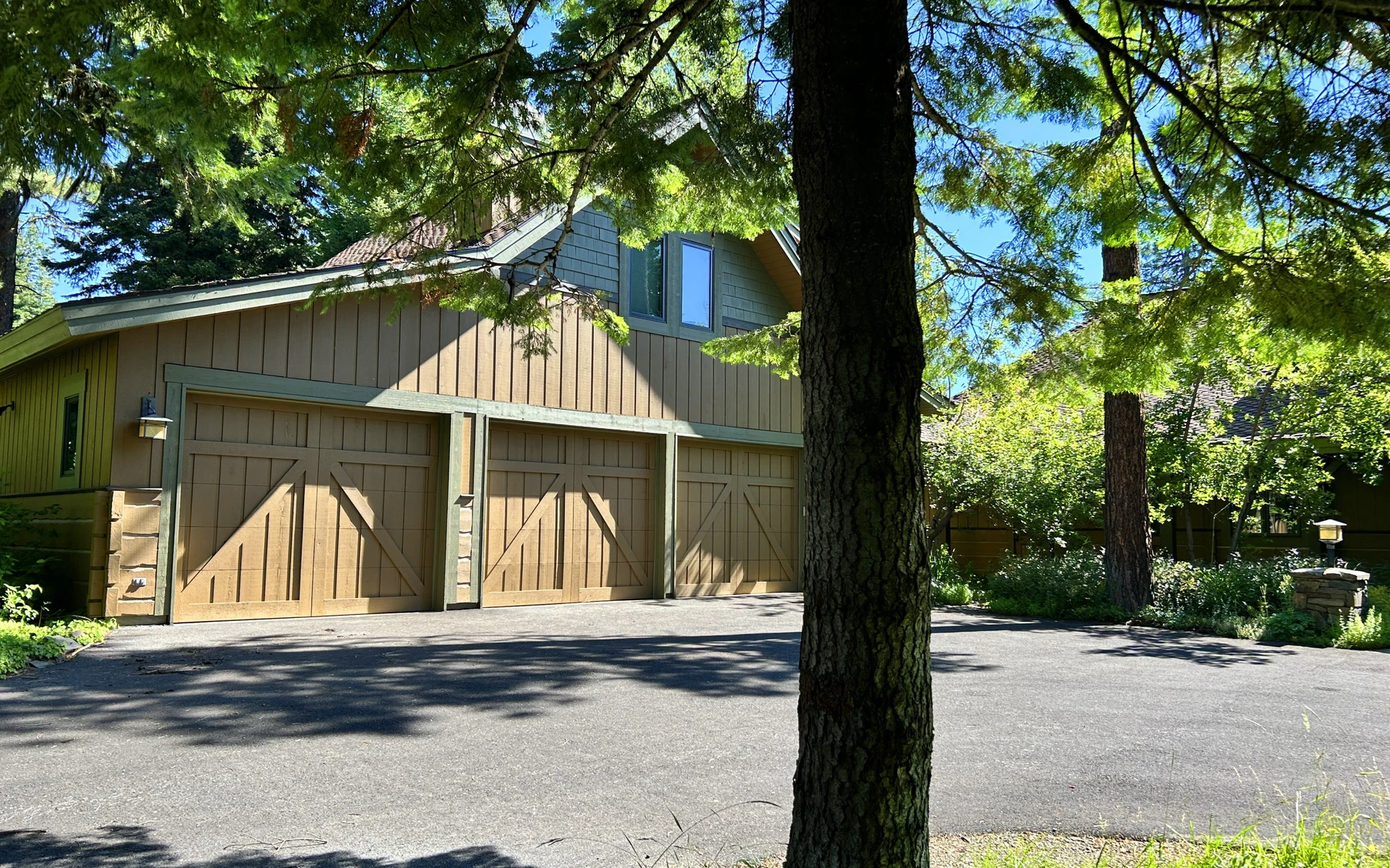 Garage approach at the Club Hill Refresh remodel at Whitetail Club, with an attached garage and a broad driveway.
