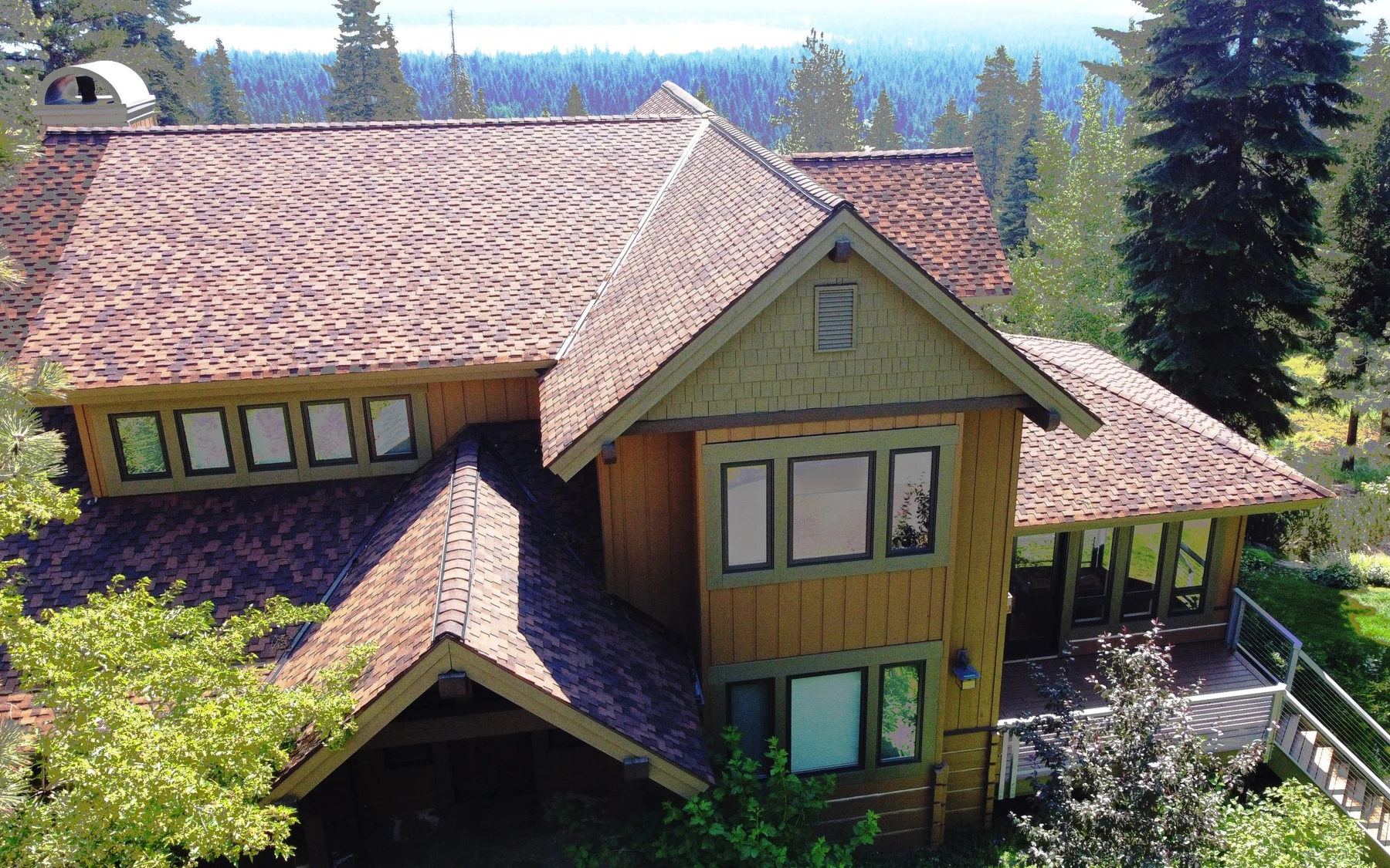Exterior of the Club Hill Refresh remodel at Whitetail Club, showing large windows and the surrounding forest.