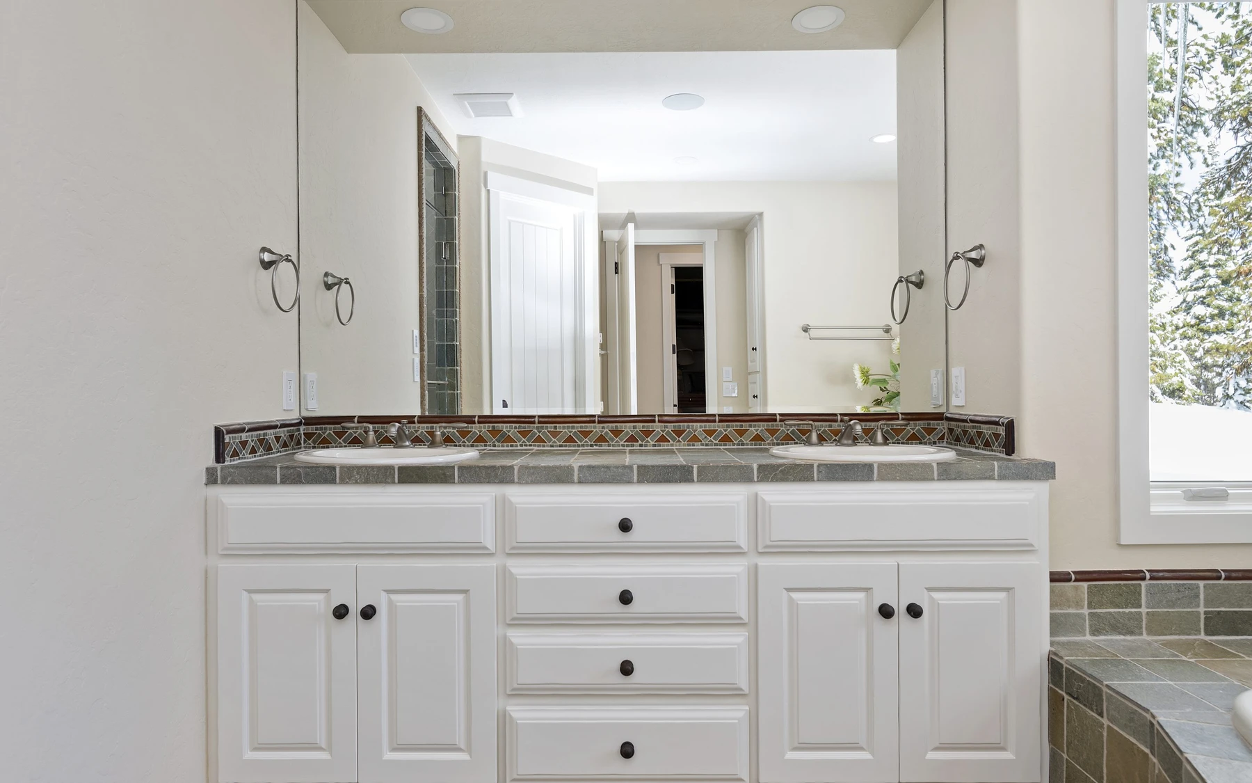 Bathroom in the Club Hill Refresh remodel at Whitetail Club, with a soaking tub, a custom vanity, and wood cabinetry.