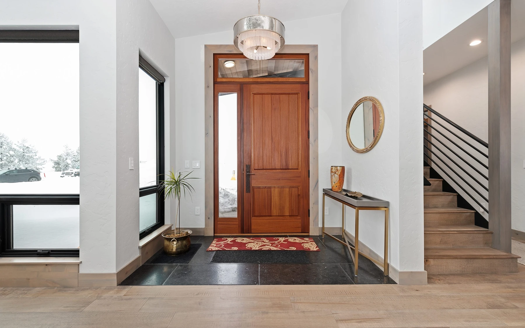 Stair hall in the Contemporary Hideaway custom home near McCall, with a custom staircase, wood railings, and natural light.