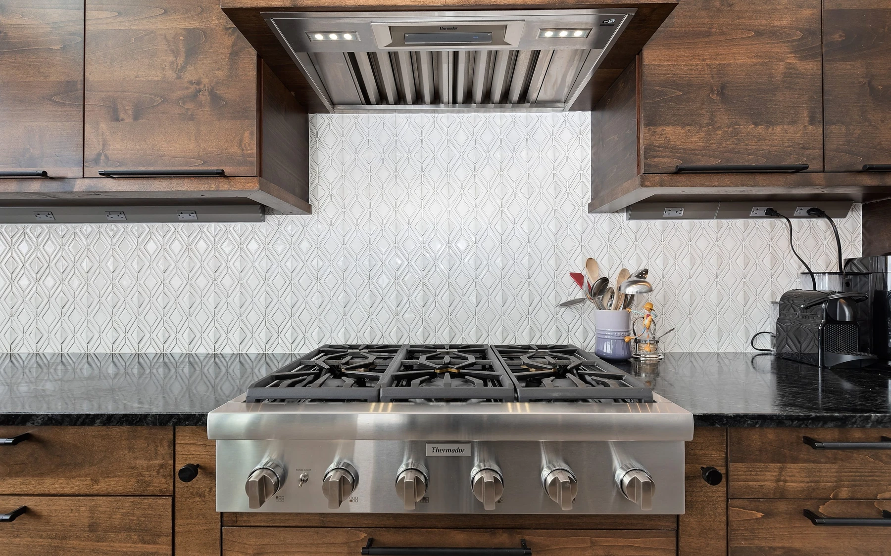 Kitchen in the Contemporary Hideaway custom home near McCall, with wood cabinetry, a broad countertop, and integrated appliances.