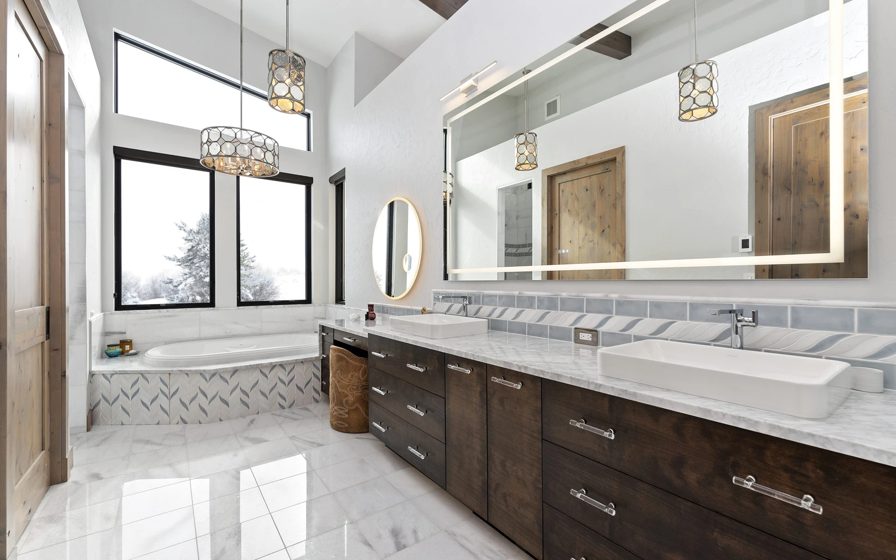 Bathroom in the Contemporary Hideaway custom home near McCall, with a soaking tub, a custom vanity, and wood cabinetry.