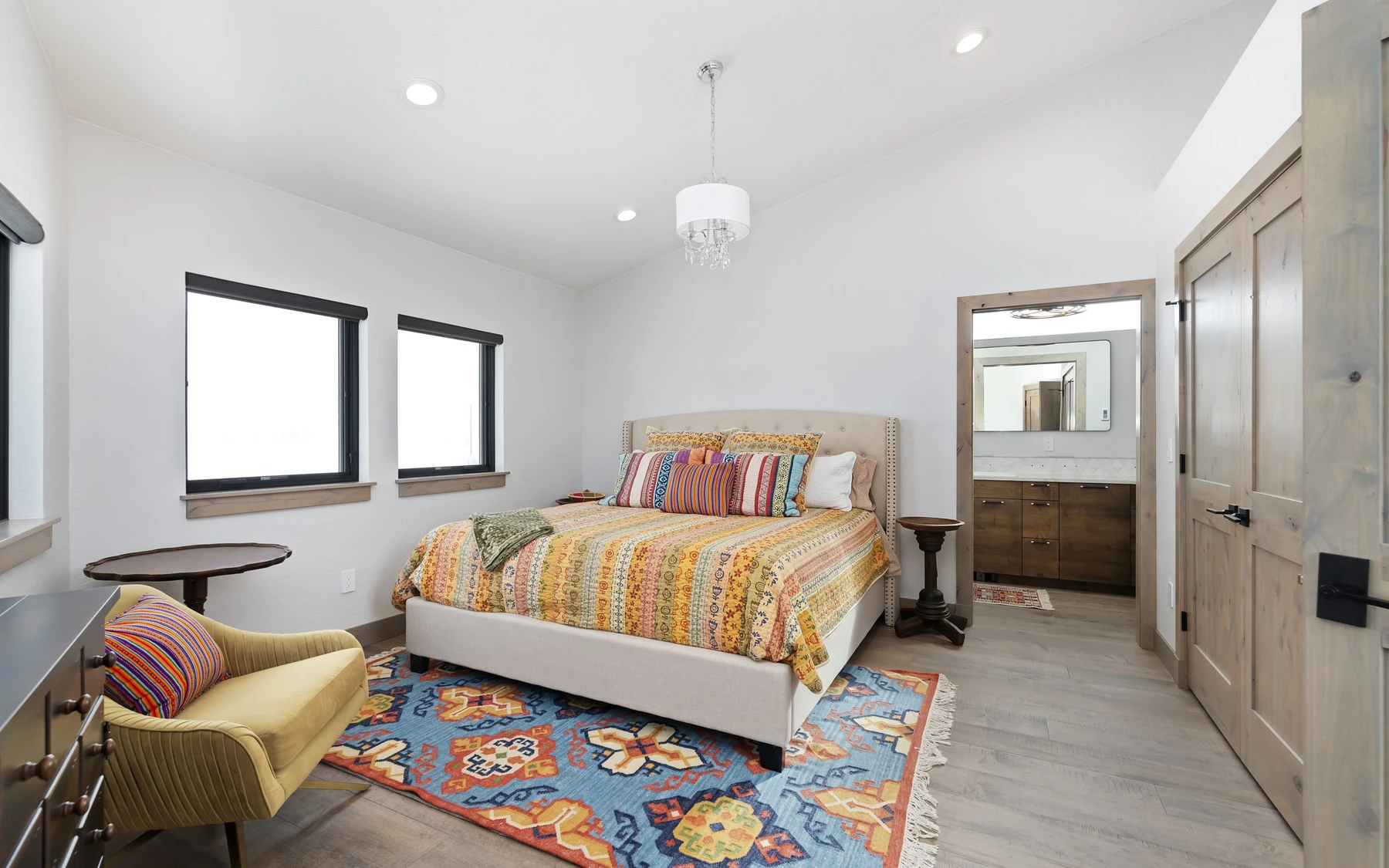 Bedroom in the Contemporary Hideaway custom home near McCall, with a layered bed, large windows, and wood details.