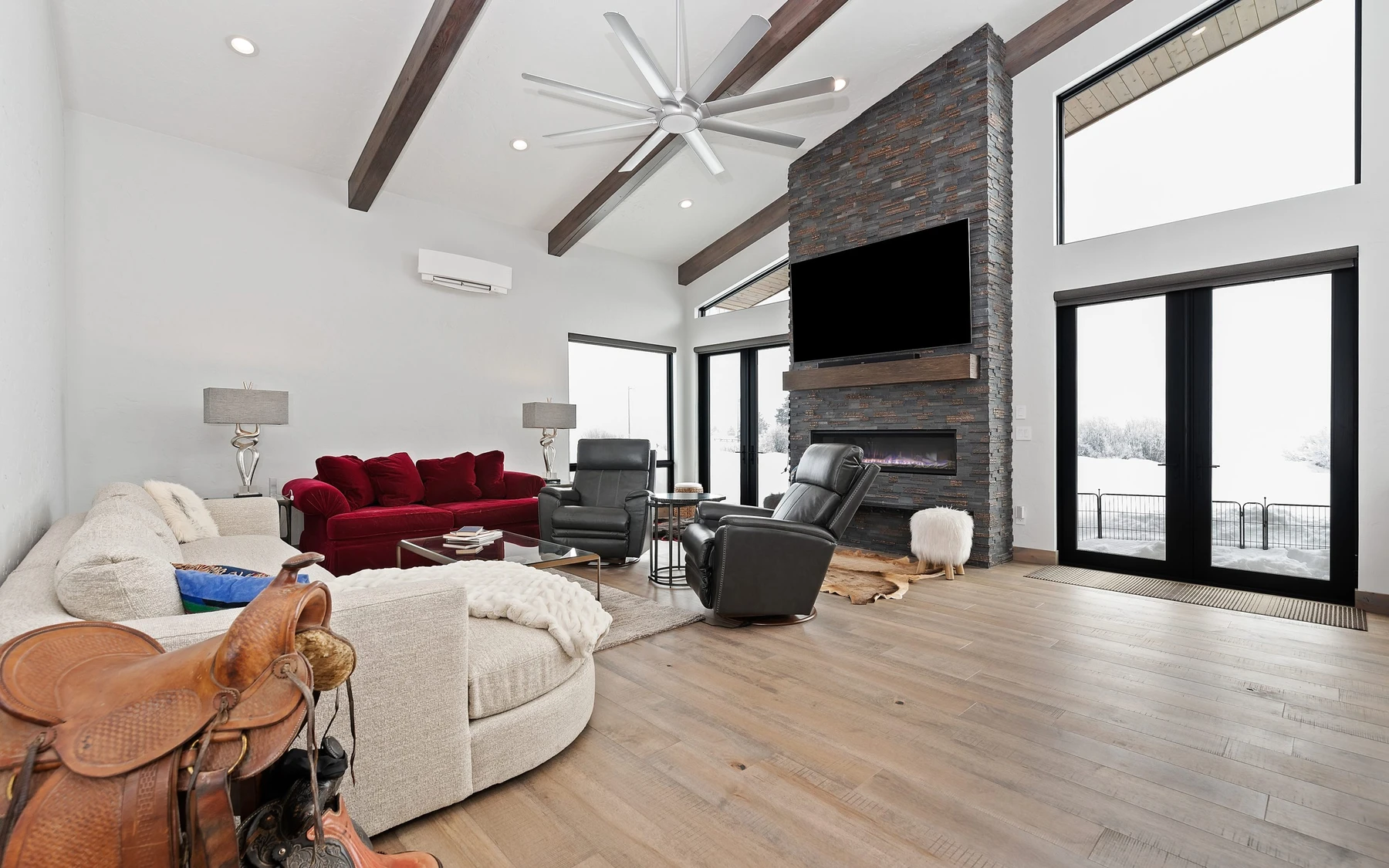 Living room in the Contemporary Hideaway custom home near McCall, with a relaxed seating area, large windows, and warm wood finishes.