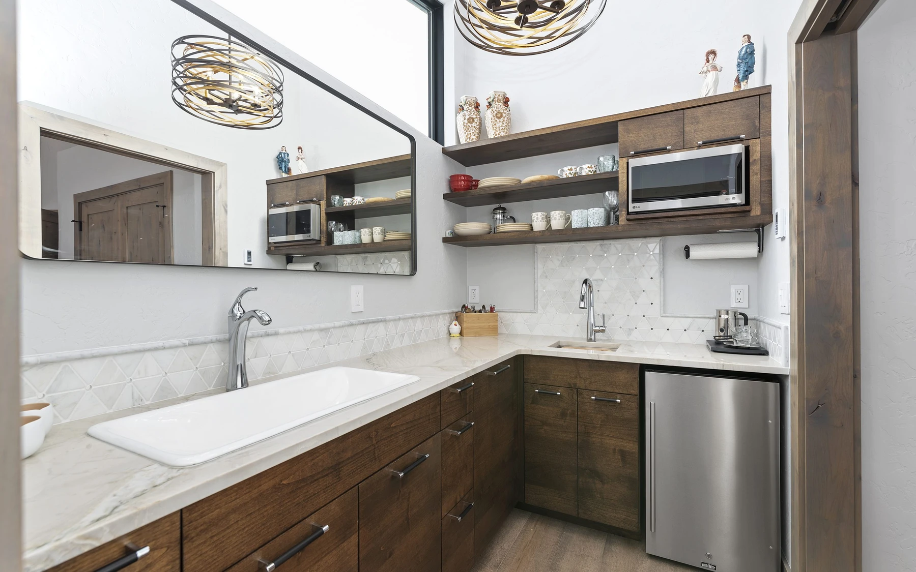 Kitchen in the Contemporary Hideaway custom home near McCall, with wood cabinetry, a broad countertop, and integrated appliances.