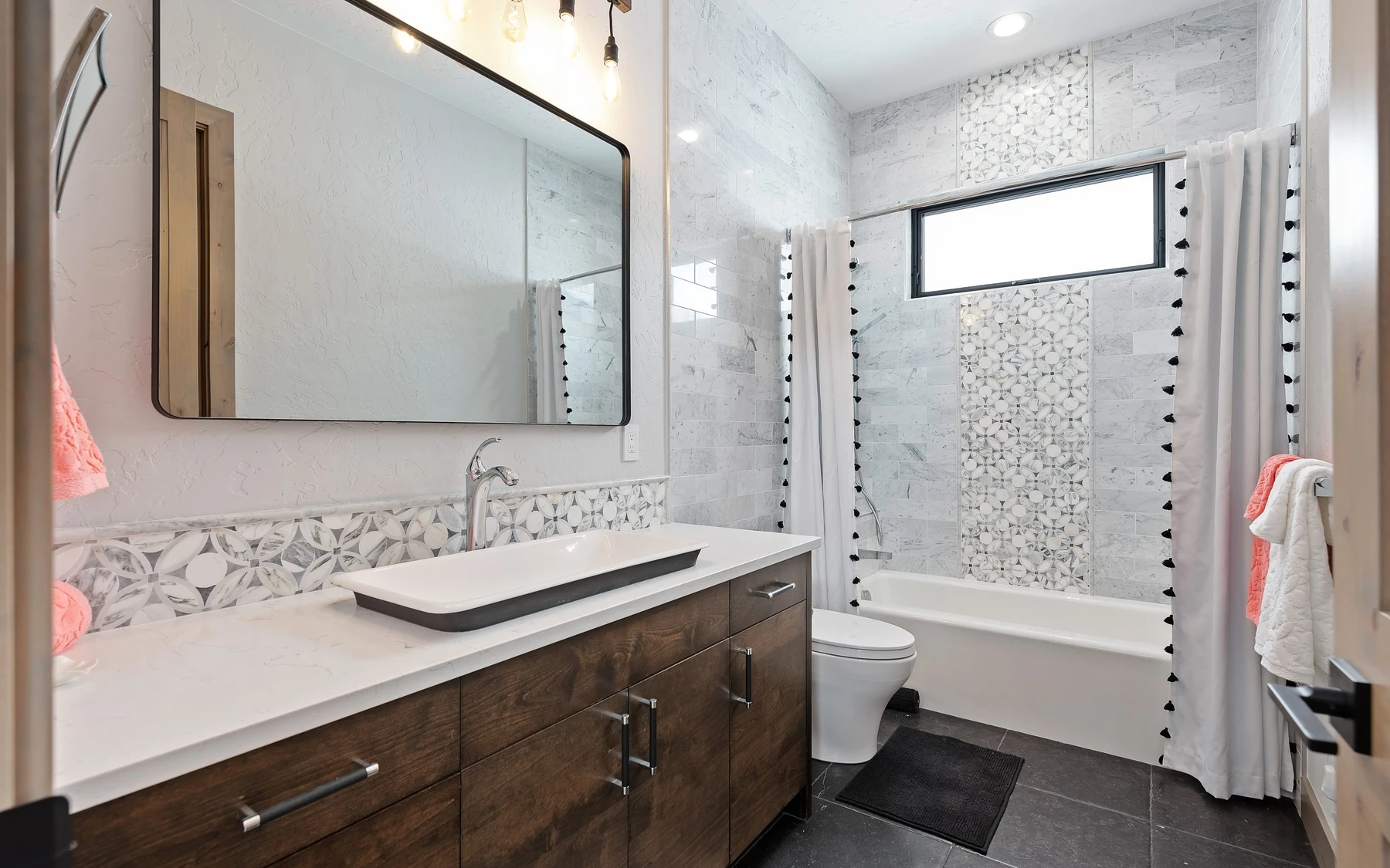 Bathroom in the Contemporary Hideaway custom home near McCall, with a soaking tub, a custom vanity, and wood cabinetry.