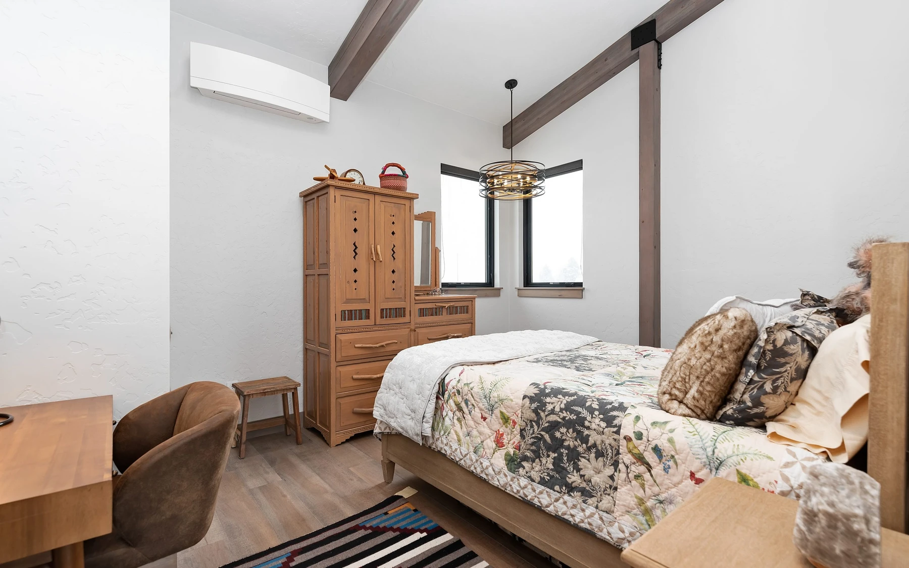Bedroom in the Contemporary Hideaway custom home near McCall, with a layered bed, large windows, and wood details.