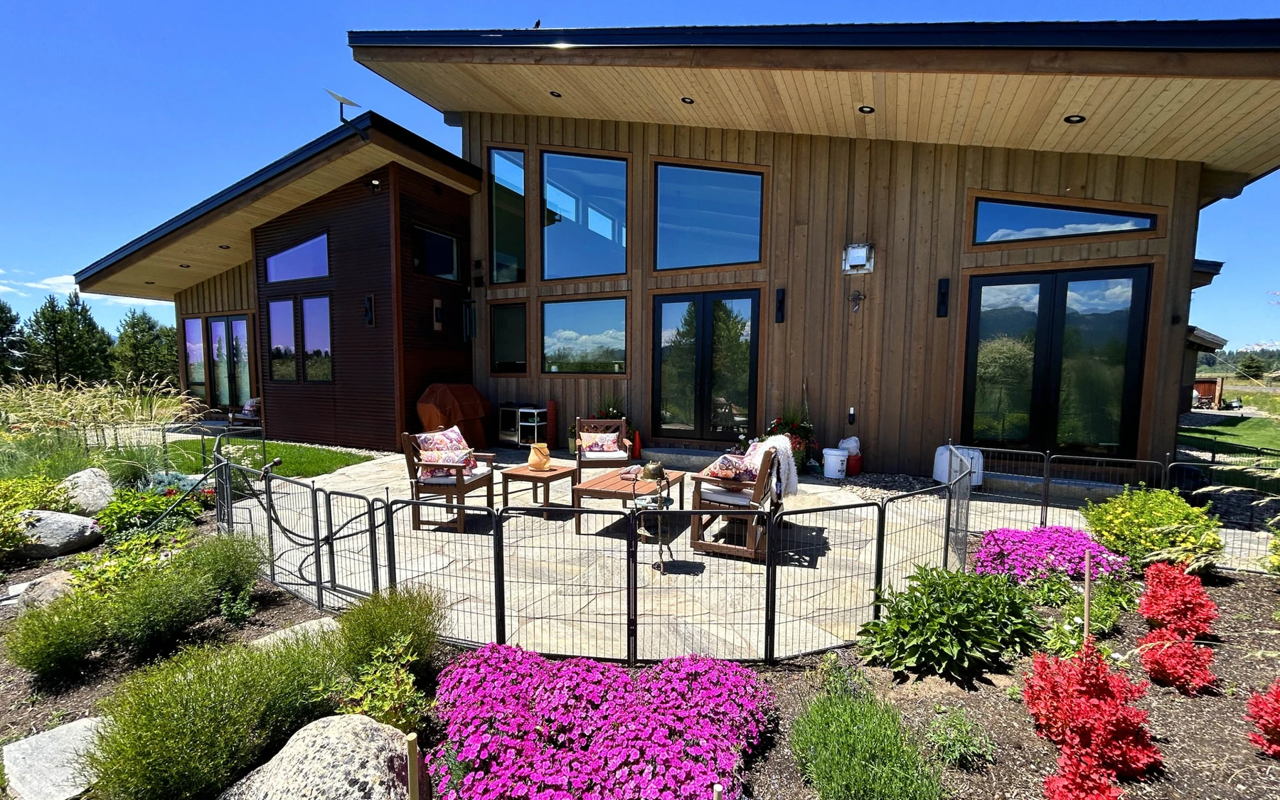 Covered outdoor space at the Contemporary Hideaway custom home near McCall, with outdoor seating and timber details.