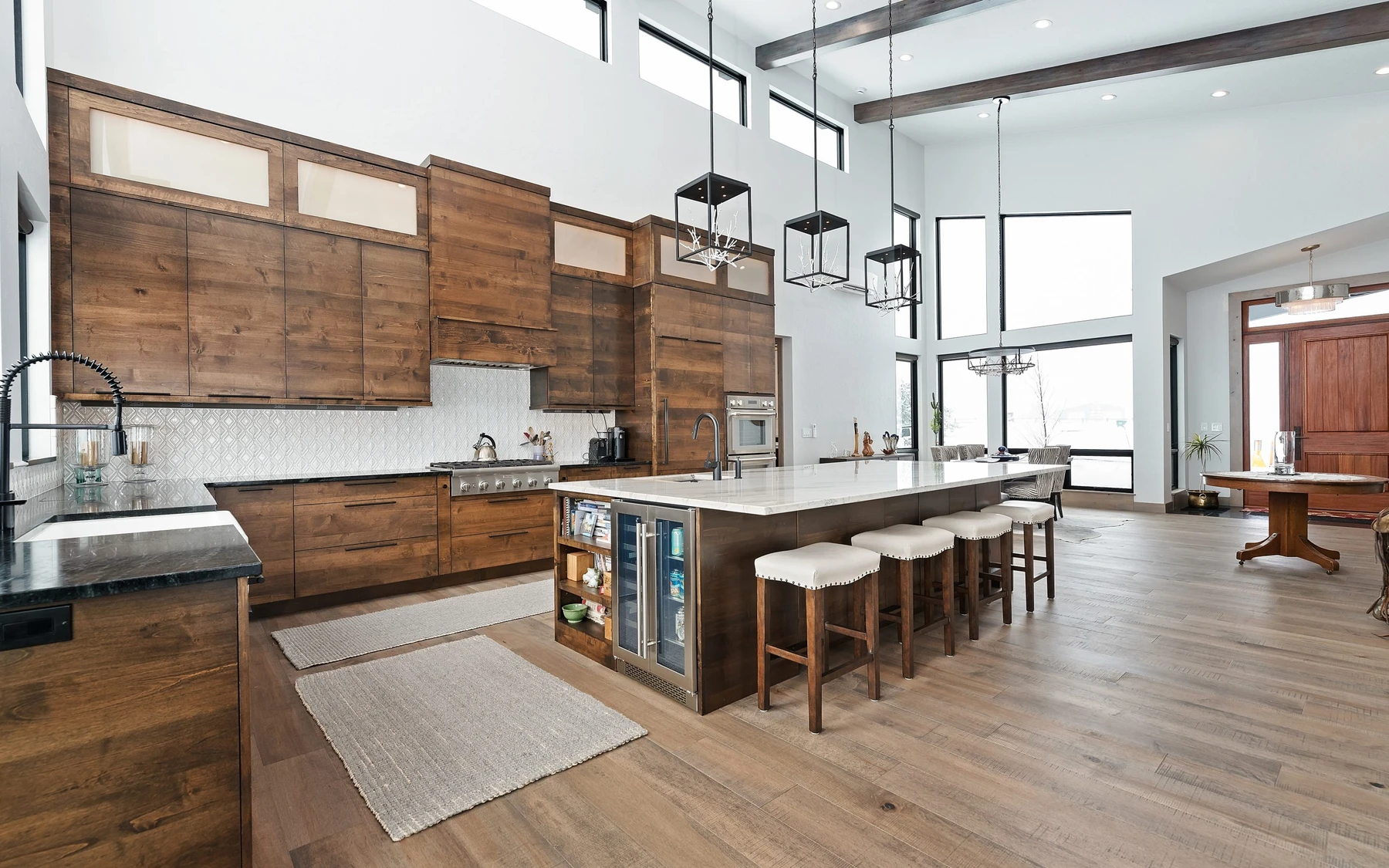 Kitchen in the Contemporary Hideaway custom home near McCall, with wood cabinetry, a broad countertop, and large windows.