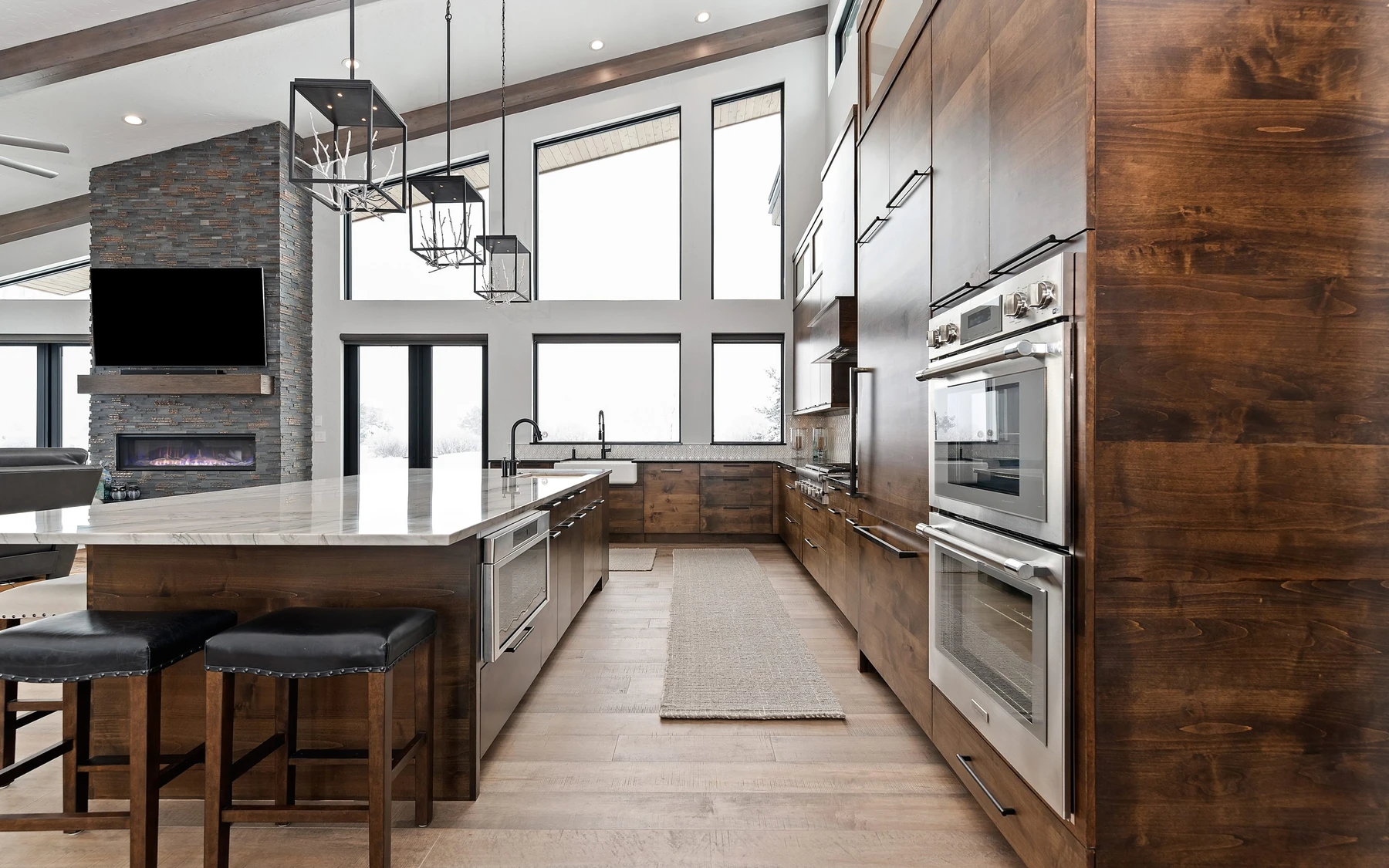 Kitchen in the Contemporary Hideaway custom home near McCall, with wood cabinetry, a broad countertop, and integrated appliances.