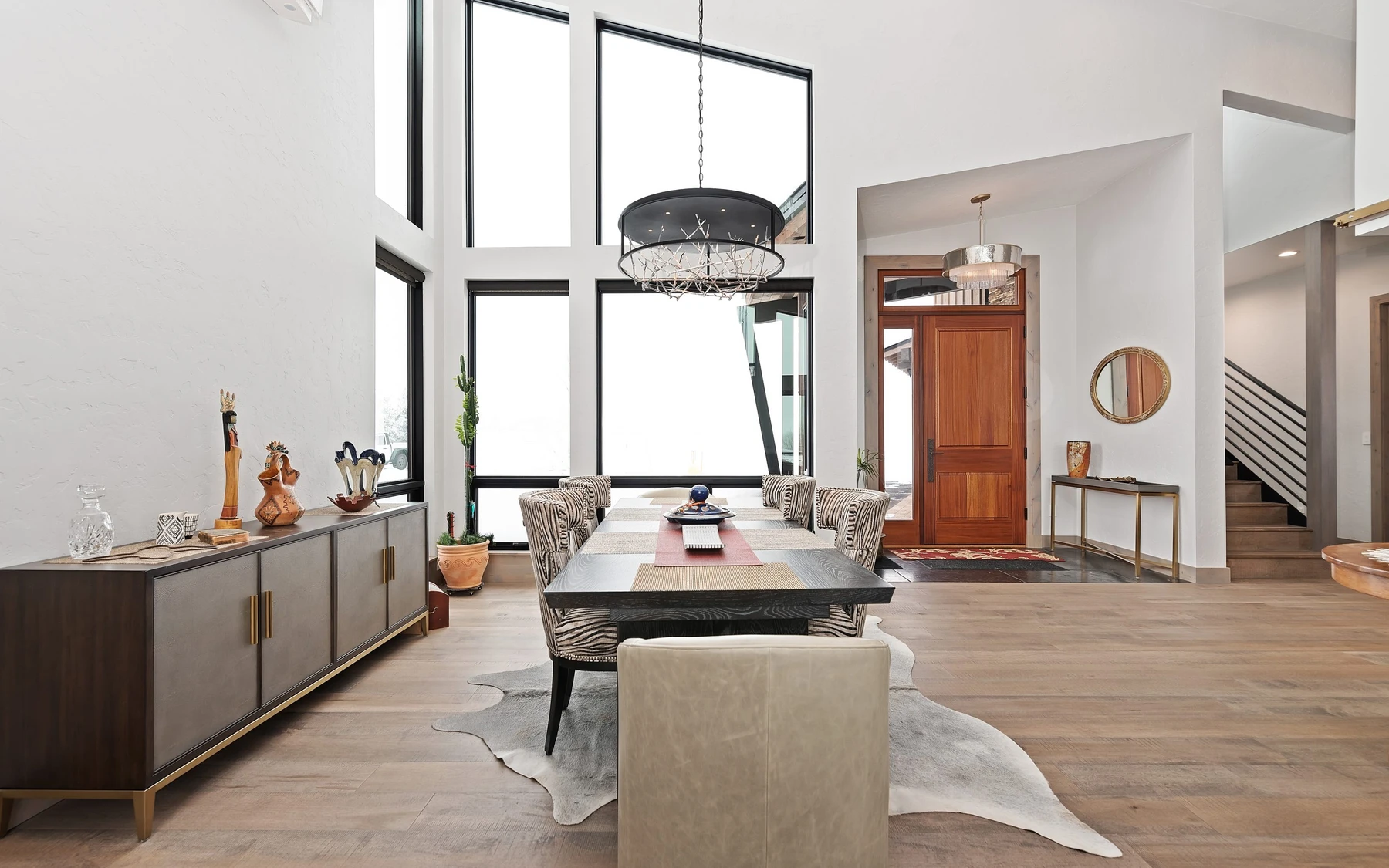 Dining room in the Contemporary Hideaway custom home near McCall, with a dining table, large windows, and wood finishes.