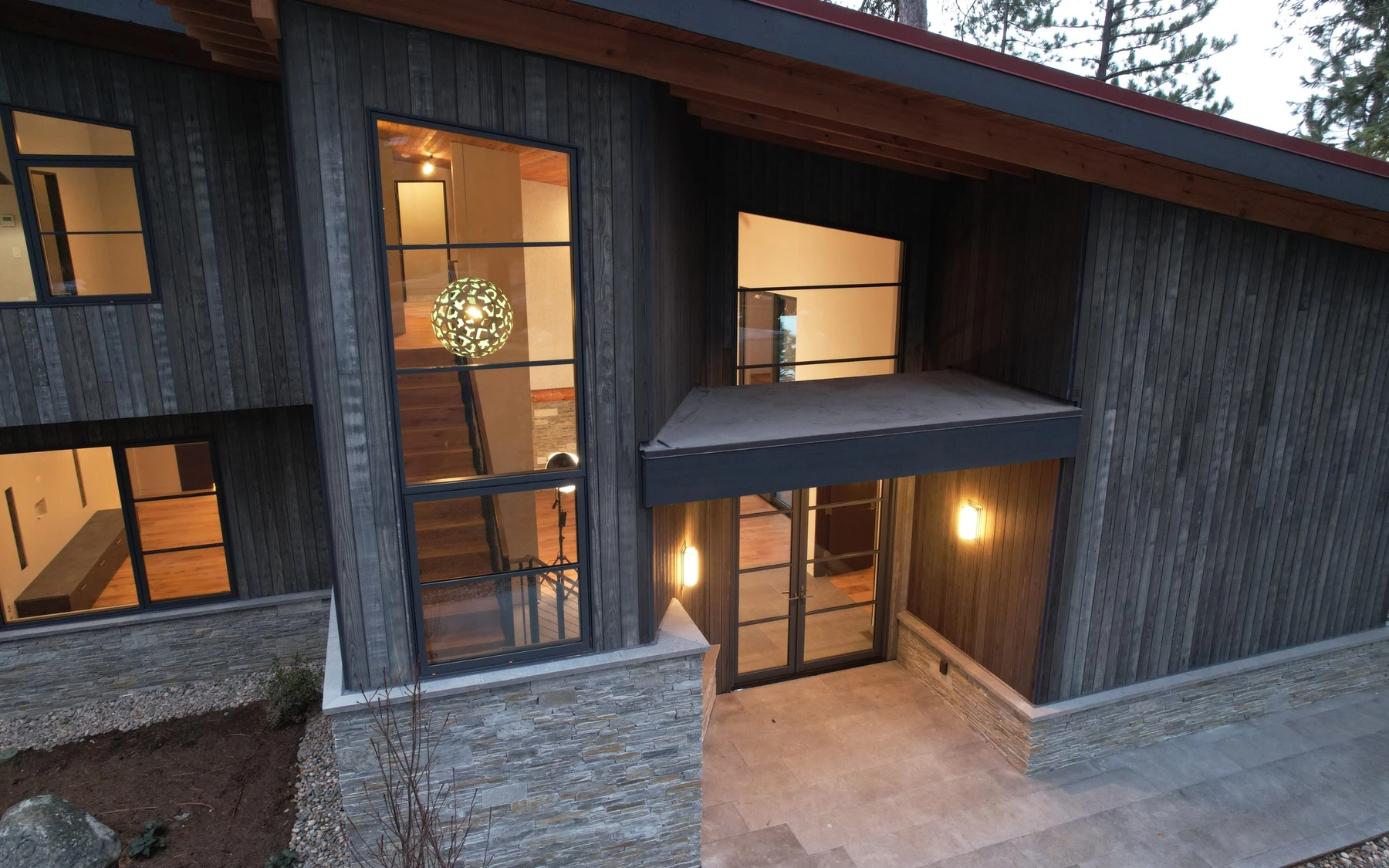 Aerial view of the Modern Elegance custom home near McCall, showing its rooflines and the surrounding landscape.