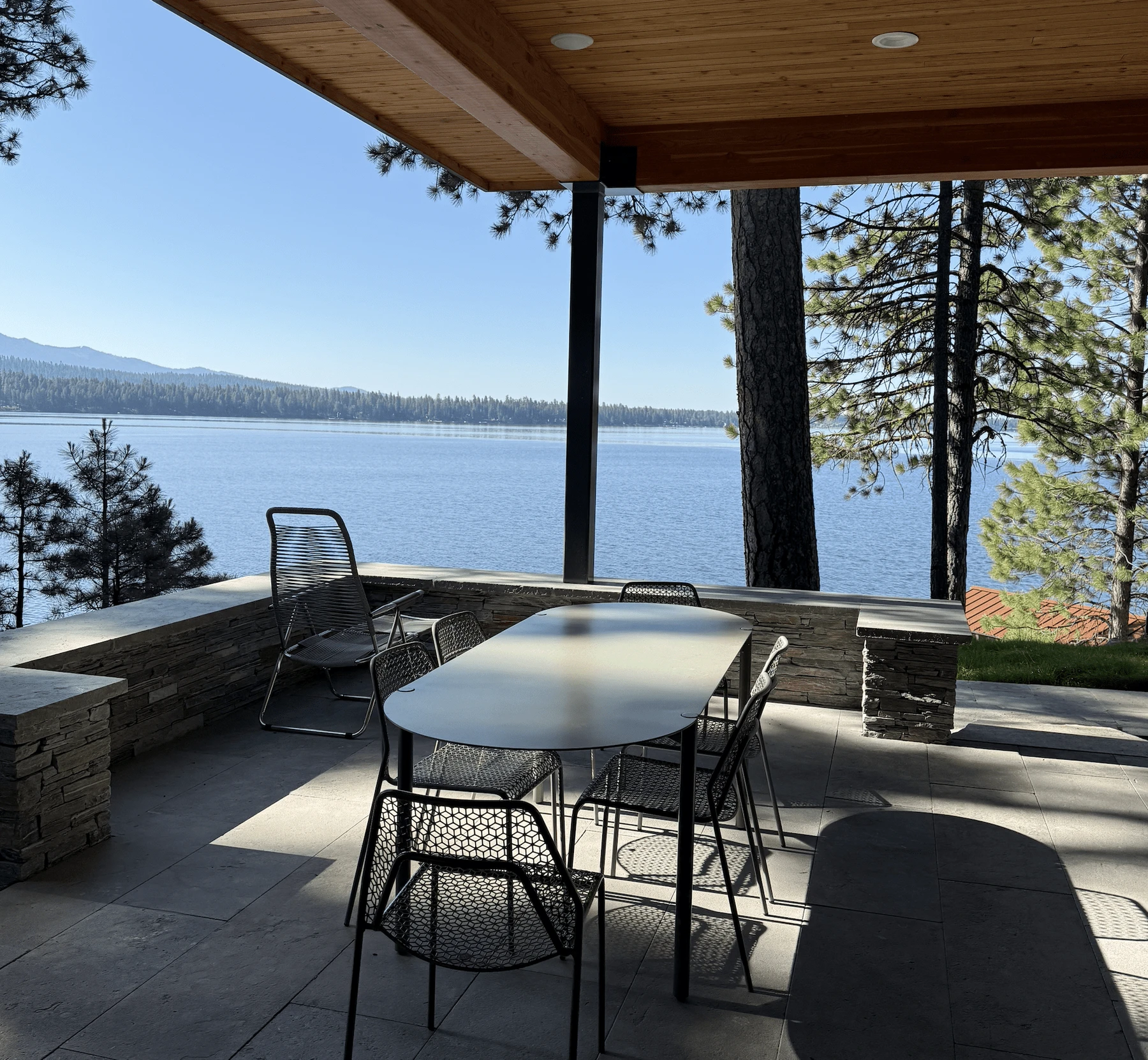 Exterior of the Modern Elegance custom home near McCall, showing wood siding and timber details, stonework, and the lakeside setting.
