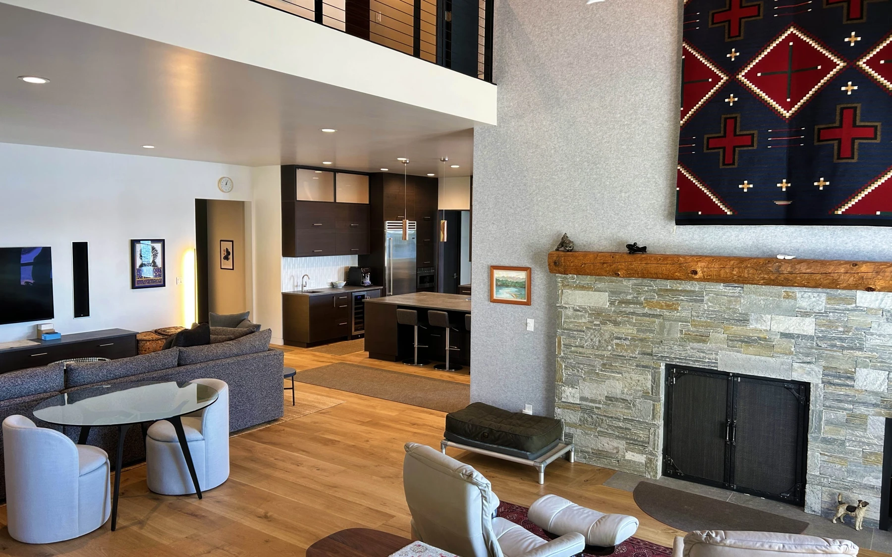 Living room in the Modern Elegance custom home near McCall, with a fireplace, a relaxed seating area, and warm wood finishes.