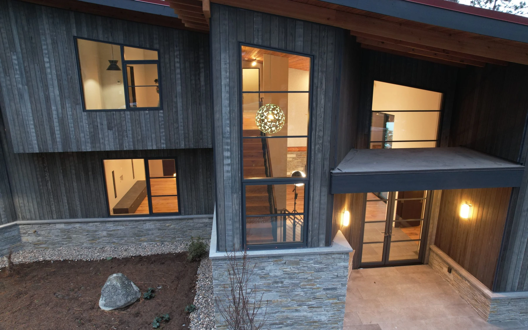 Aerial view of the Modern Elegance custom home near McCall, showing its rooflines and the surrounding landscape.