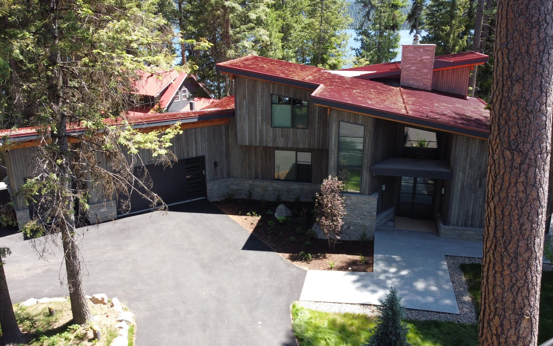 Aerial view of the Modern Elegance custom home near McCall, showing its rooflines and the surrounding landscape.