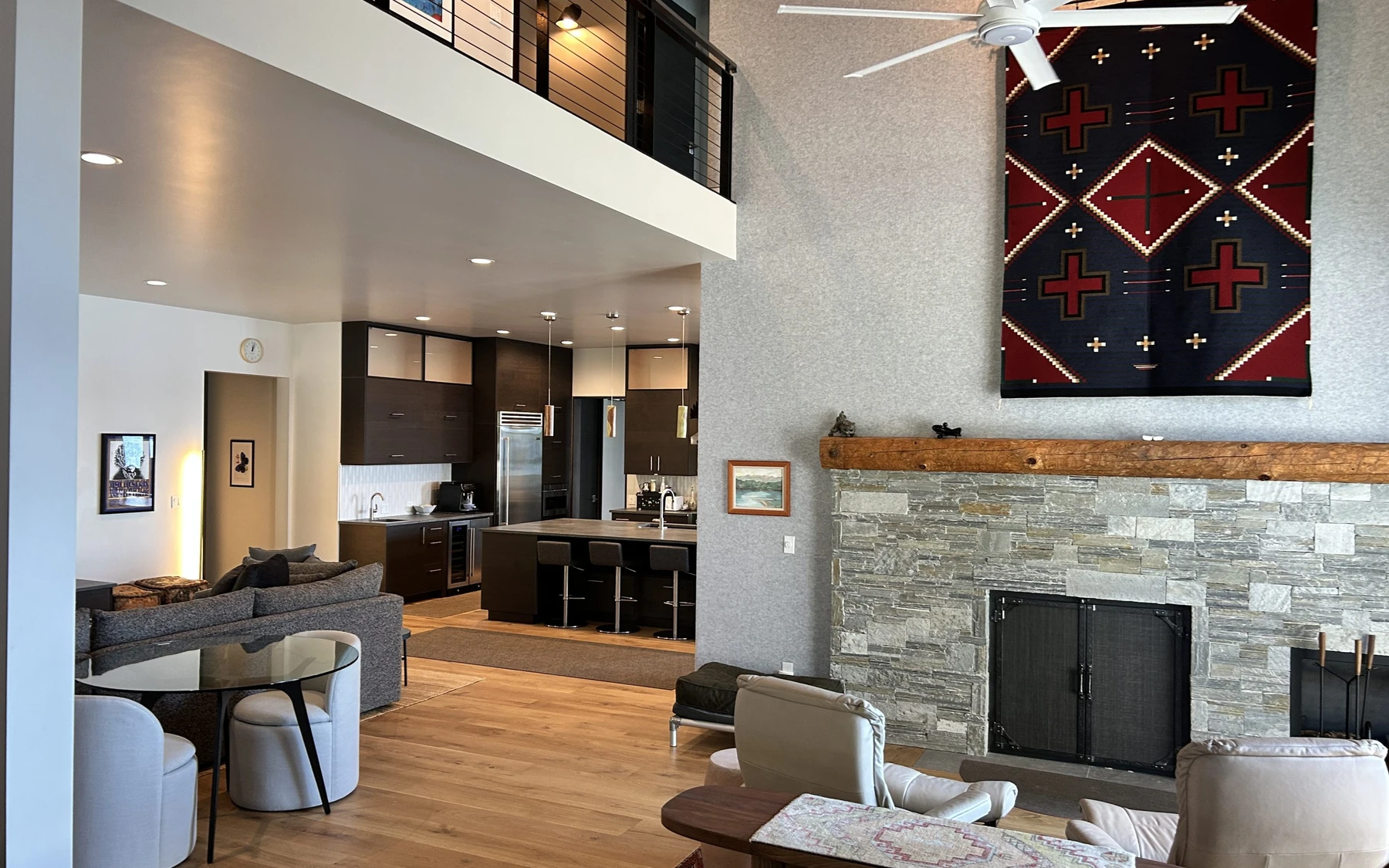 Living room in the Modern Elegance custom home near McCall, with a fireplace, a relaxed seating area, and warm wood finishes.