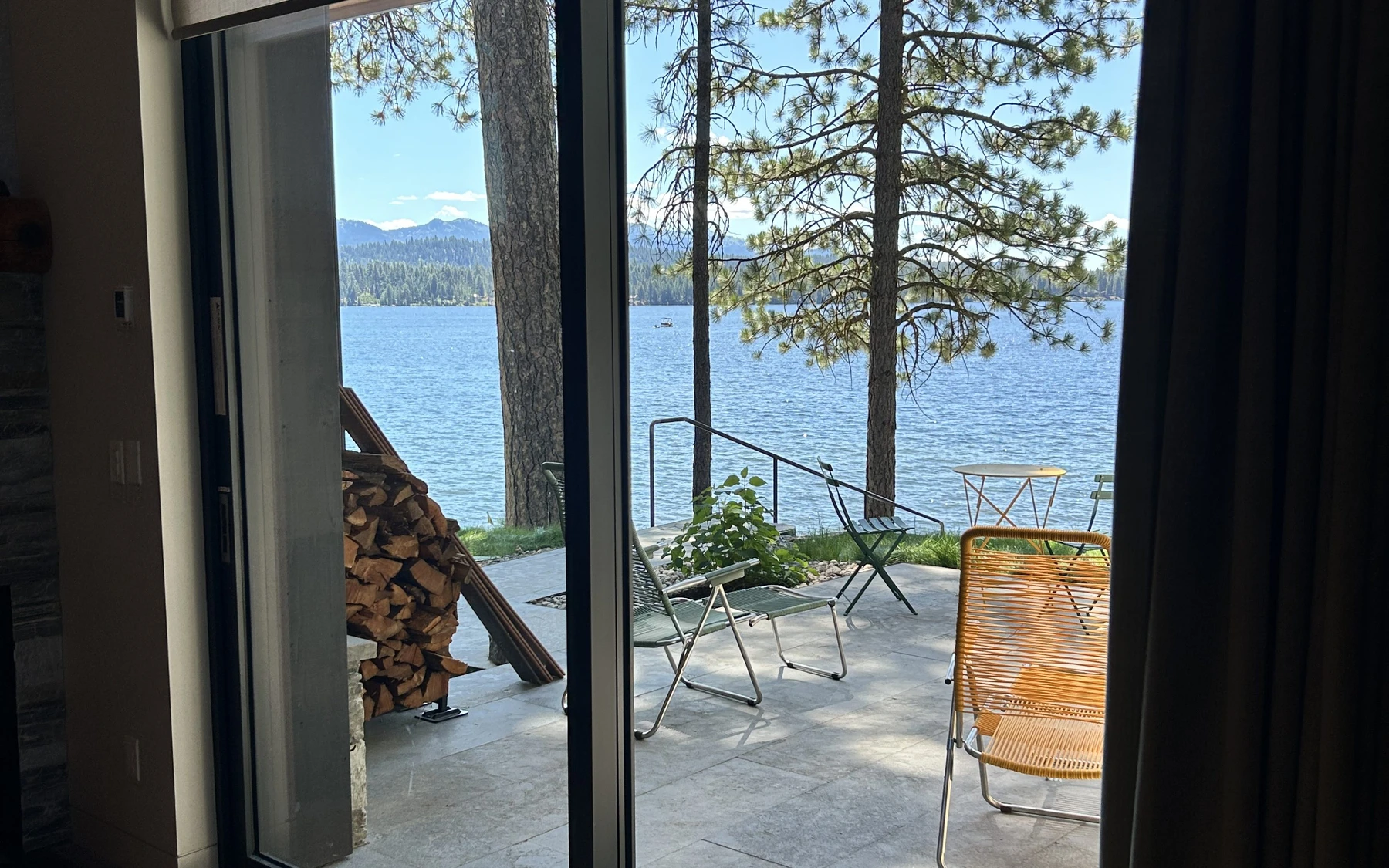 Exterior of the Modern Elegance custom home near McCall, showing wood siding and timber details, large windows, and the lakeside setting.