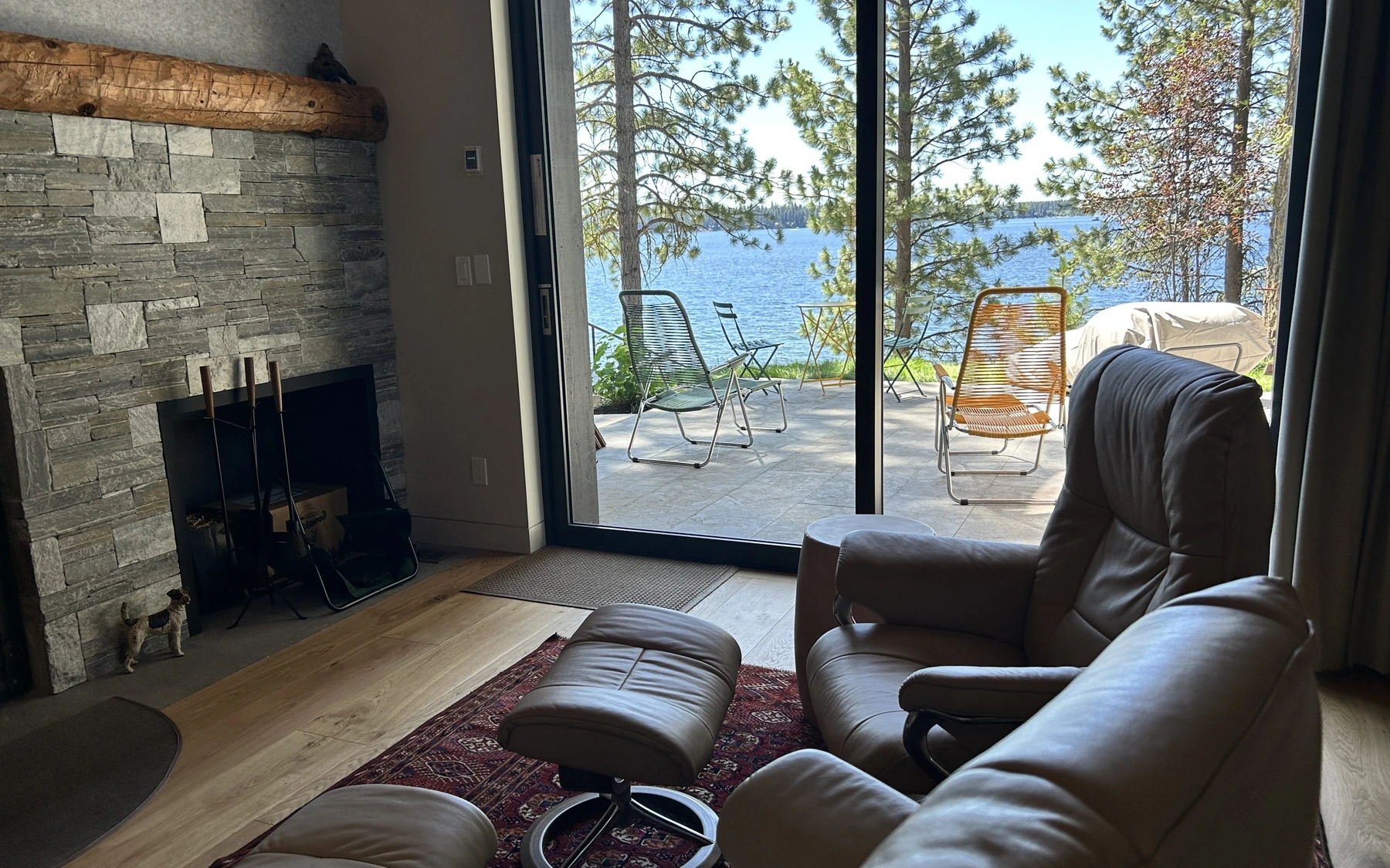 Living room in the Modern Elegance custom home near McCall, with a relaxed seating area, large windows, and warm wood finishes.