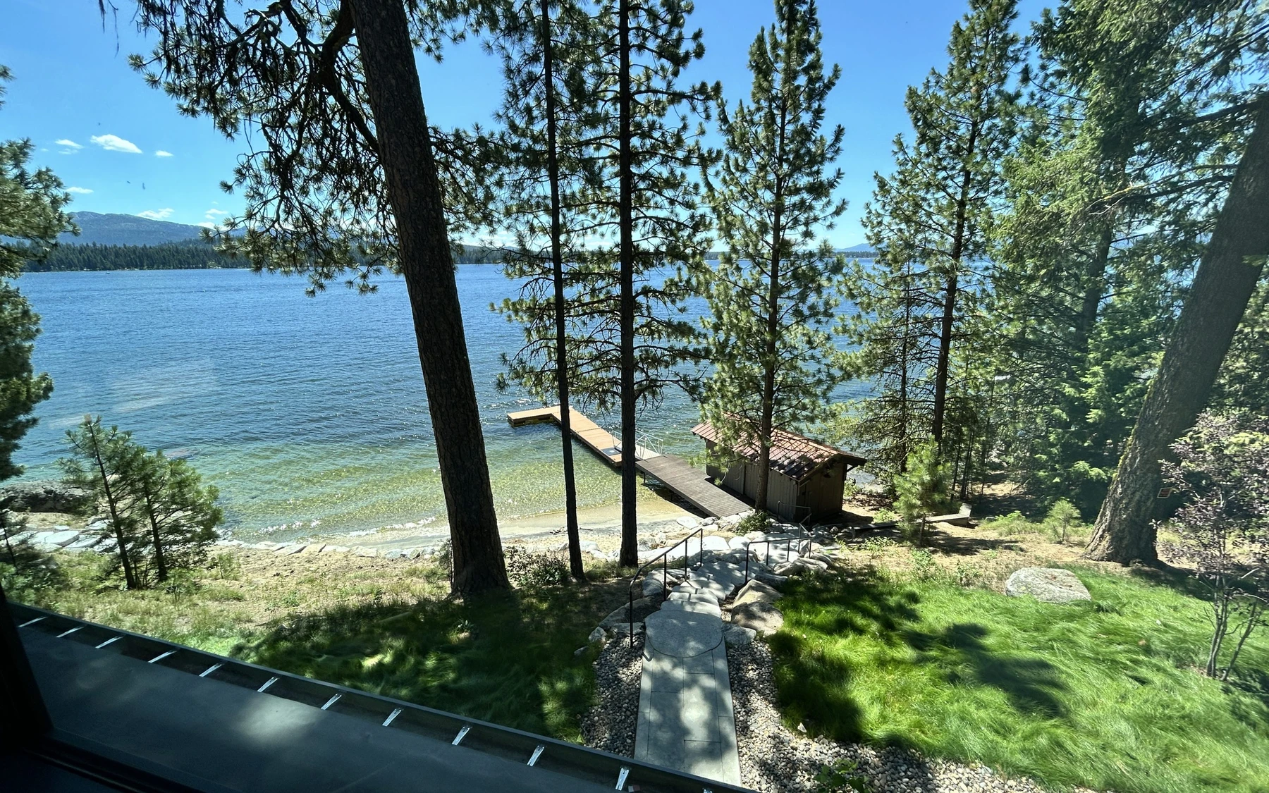 Exterior of the Modern Elegance custom home near McCall, showing wood siding and timber details, stonework, and the lakeside setting.