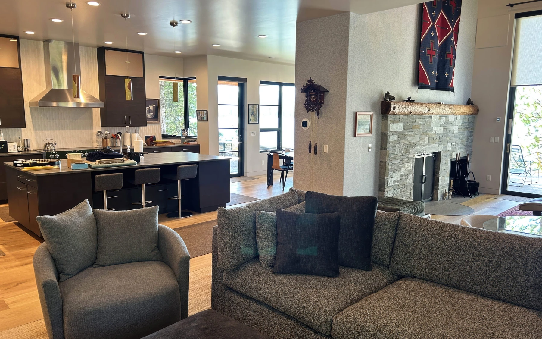 Living room in the Modern Elegance custom home near McCall, with a relaxed seating area, large windows, and warm wood finishes.