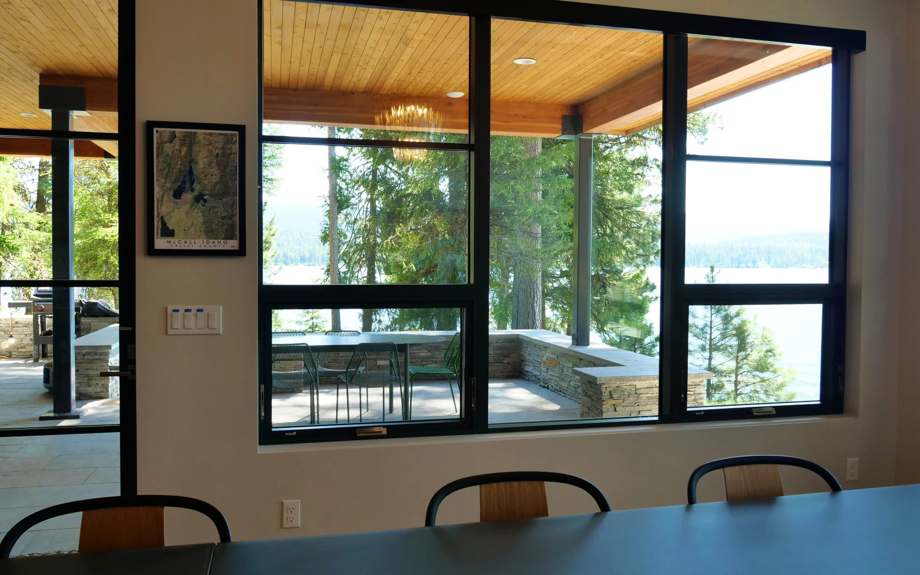 Interior detail in the Modern Elegance custom home near McCall, showing large windows, wood finishes, and framed artwork.