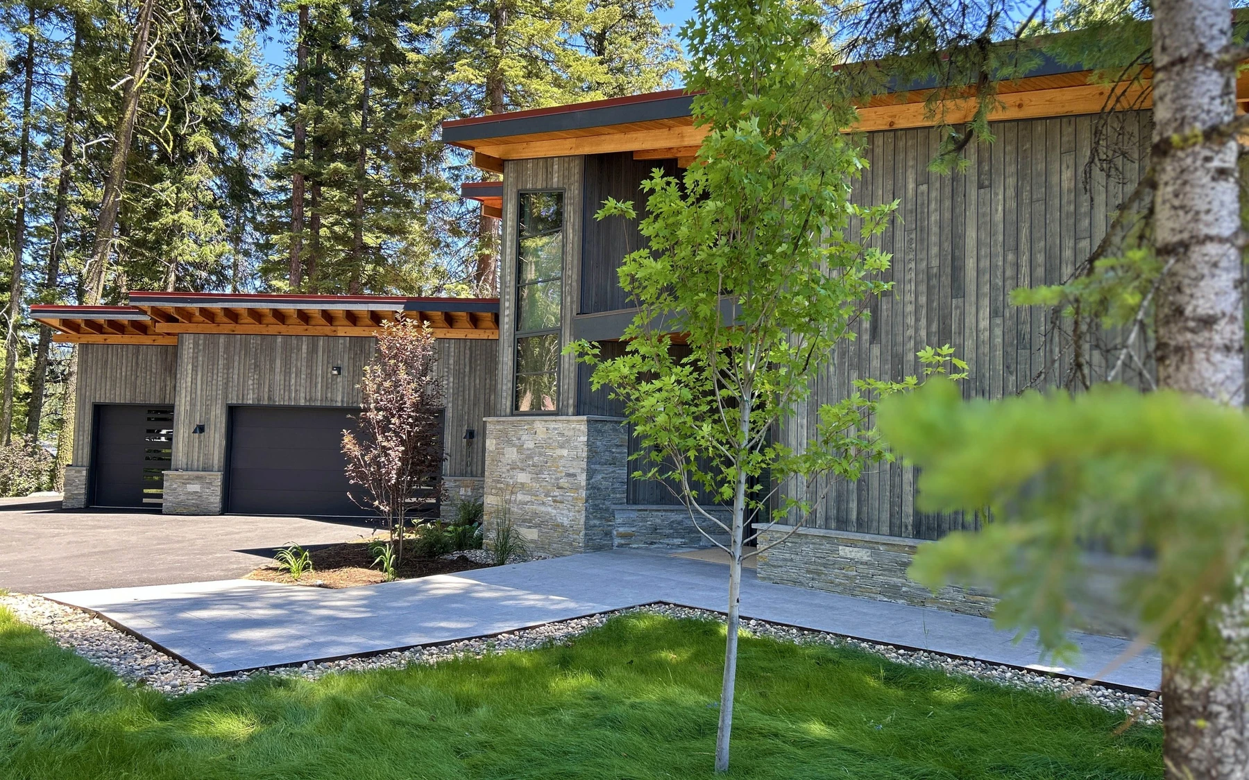 Covered outdoor space at the Modern Elegance custom home near McCall, with timber details and forest views.