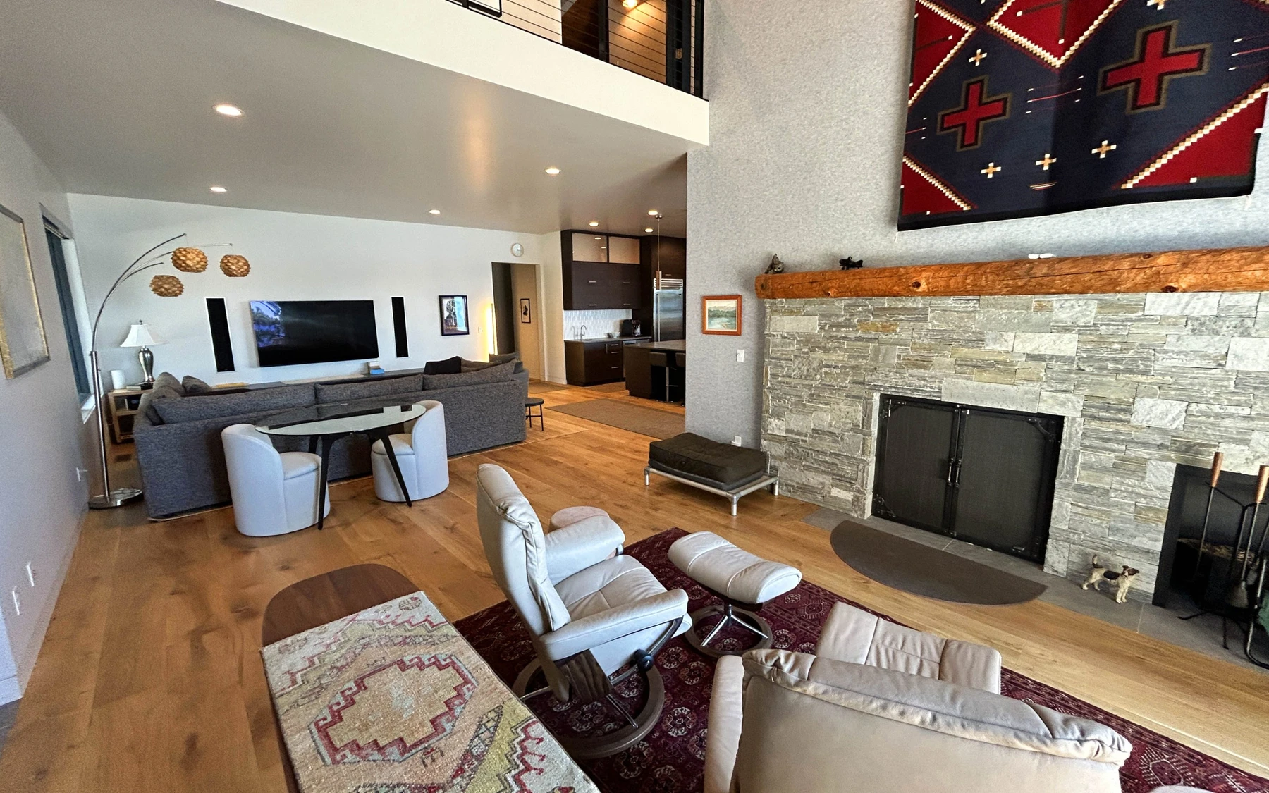 Living room in the Modern Elegance custom home near McCall, with a fireplace, a relaxed seating area, and warm wood finishes.