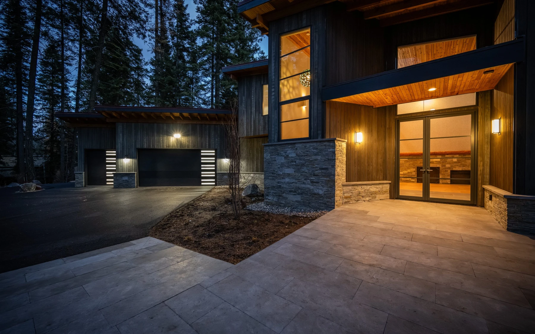 Covered outdoor space at the Modern Elegance custom home near McCall, with timber details and forest views.