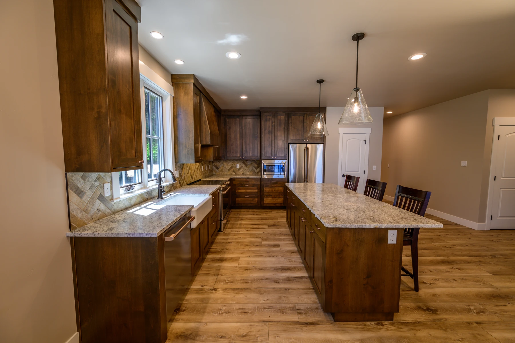 Long view through the kitchen showing dual work aisles and extensive cabinet storage