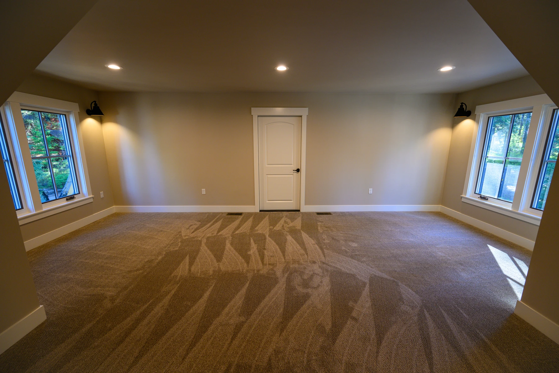 Large upper flex room with a low sloped ceiling and windows on two sides