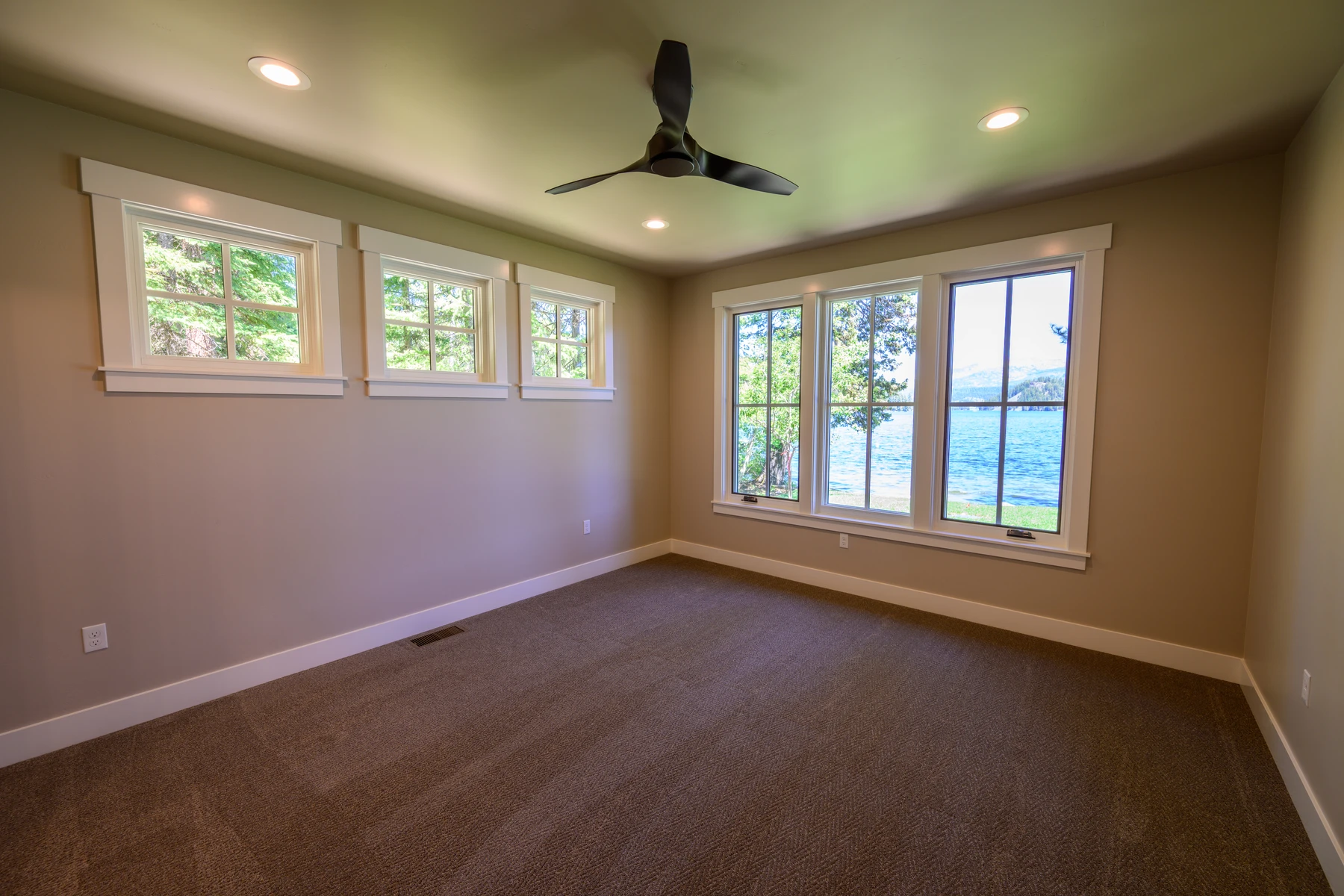Lake-facing bedroom with corner windows and glass doors to the lawn