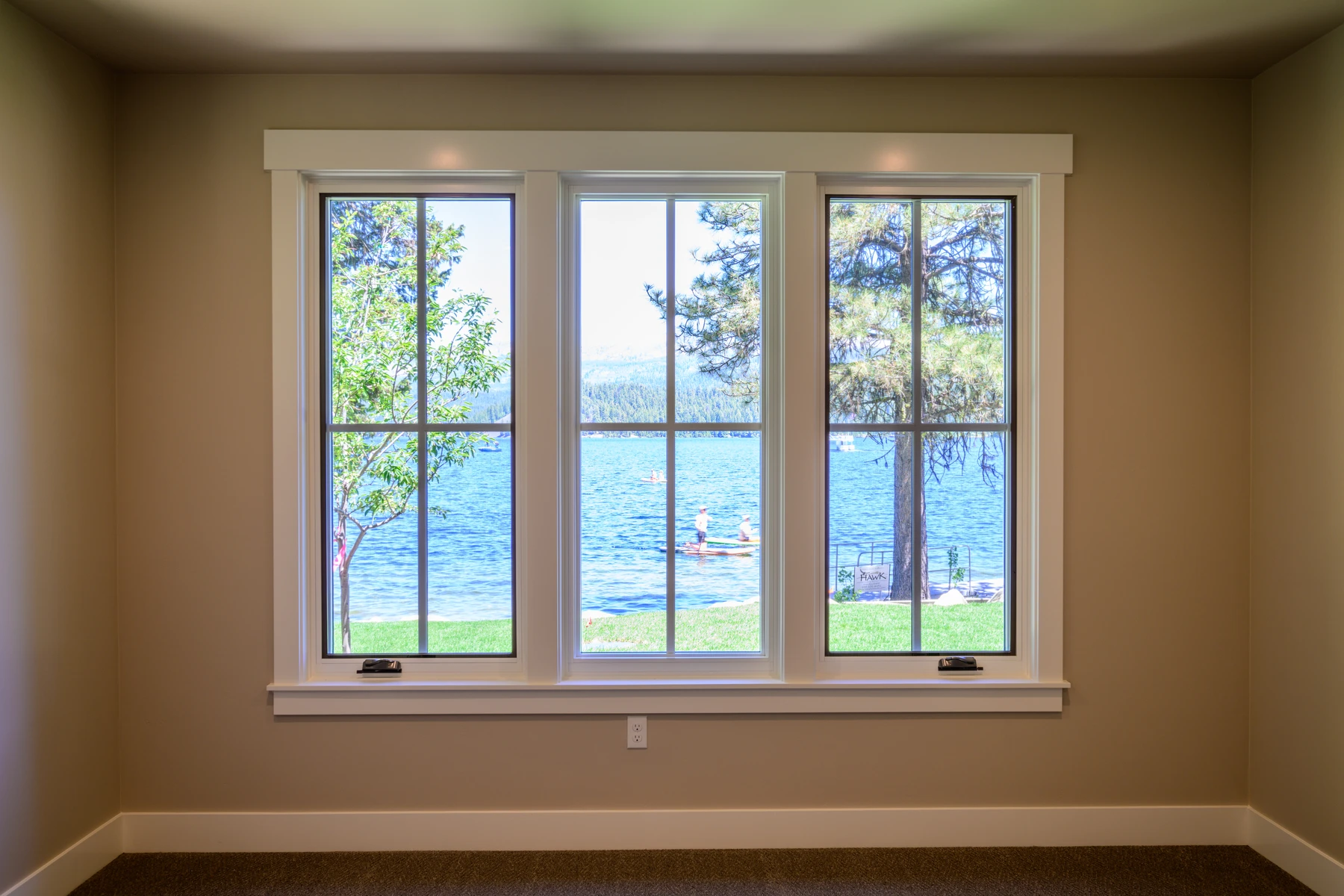 Bedroom window framing a direct view of the lake and shoreline trees