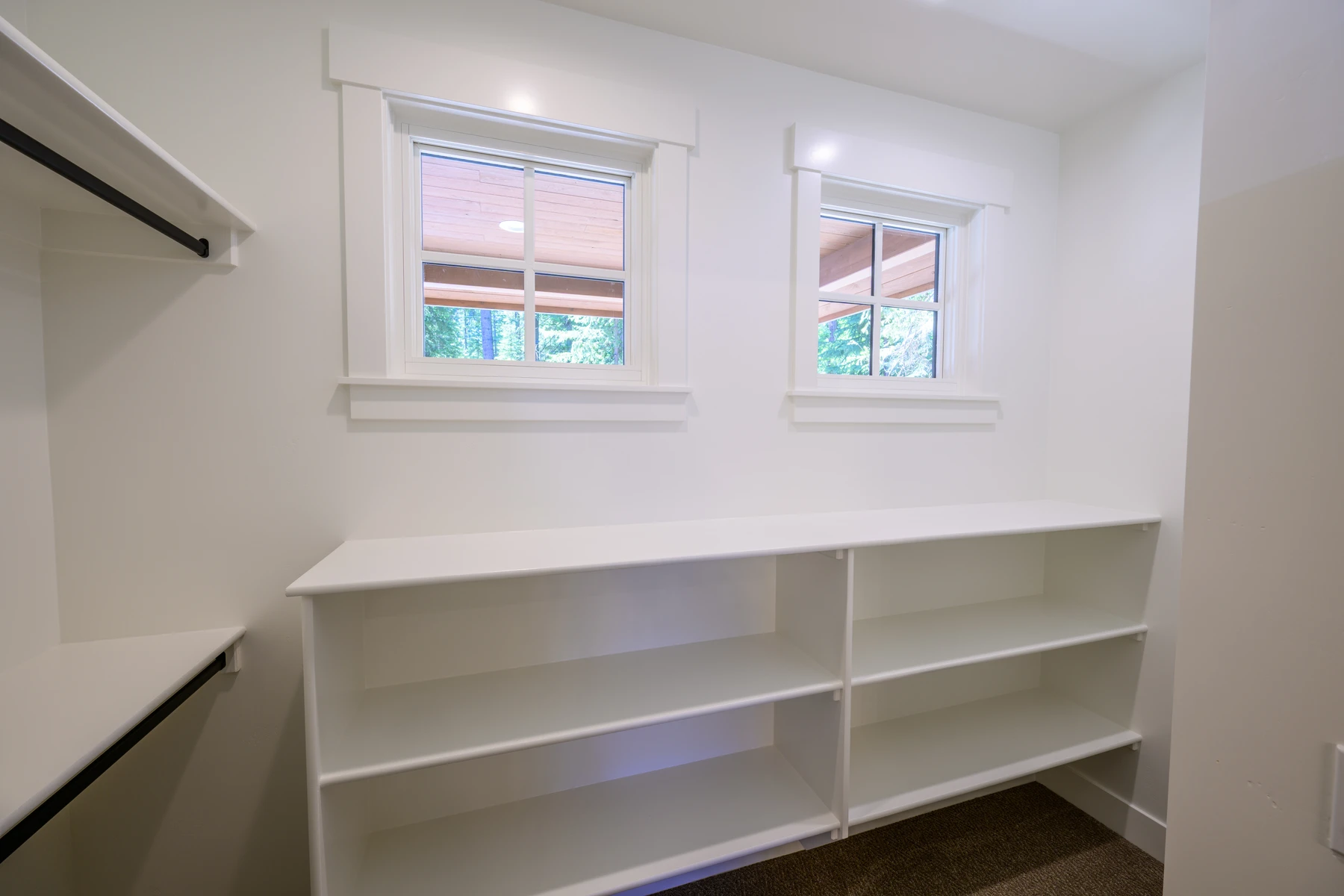 Walk-in closet with built-in white shelving and natural light