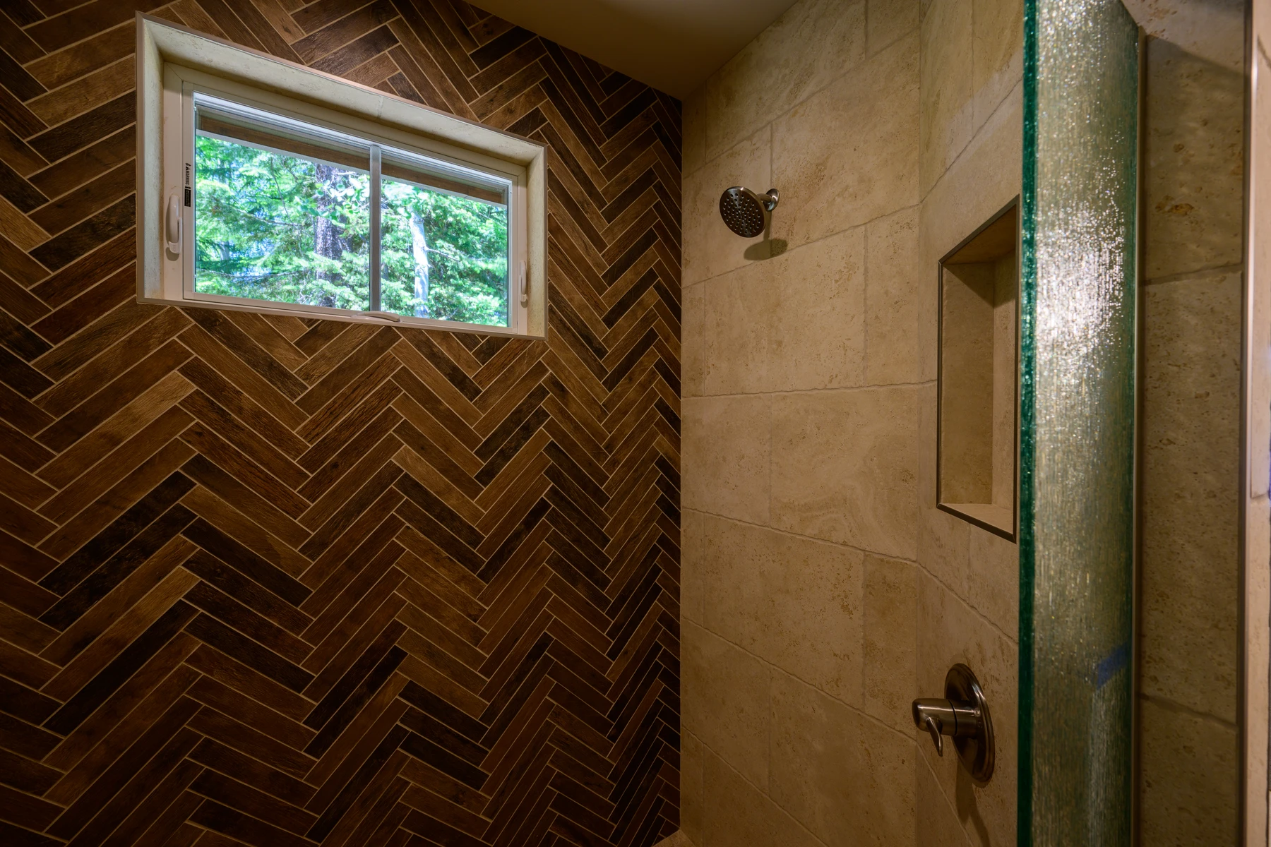 Brown herringbone tile detail and high forest window inside the shower
