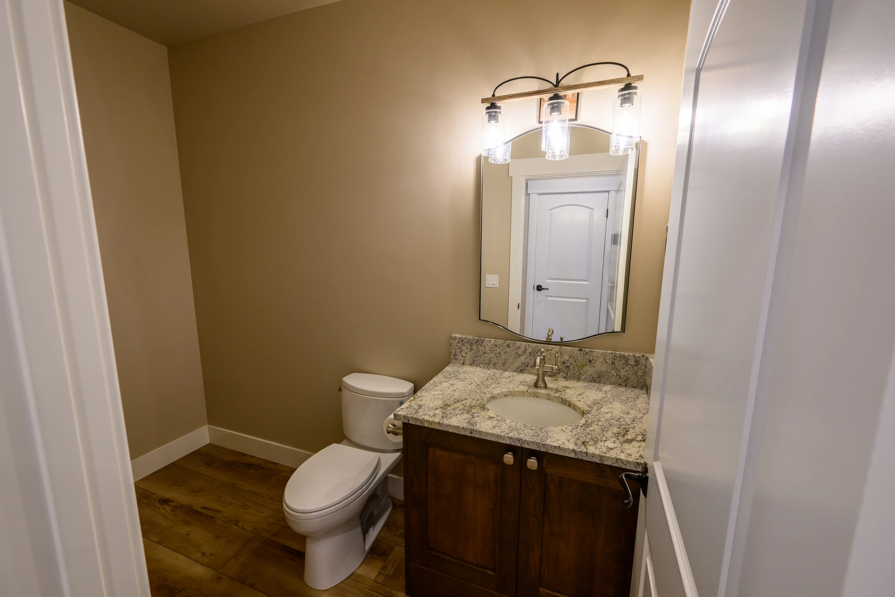 Compact bathroom with a stone-topped wood vanity