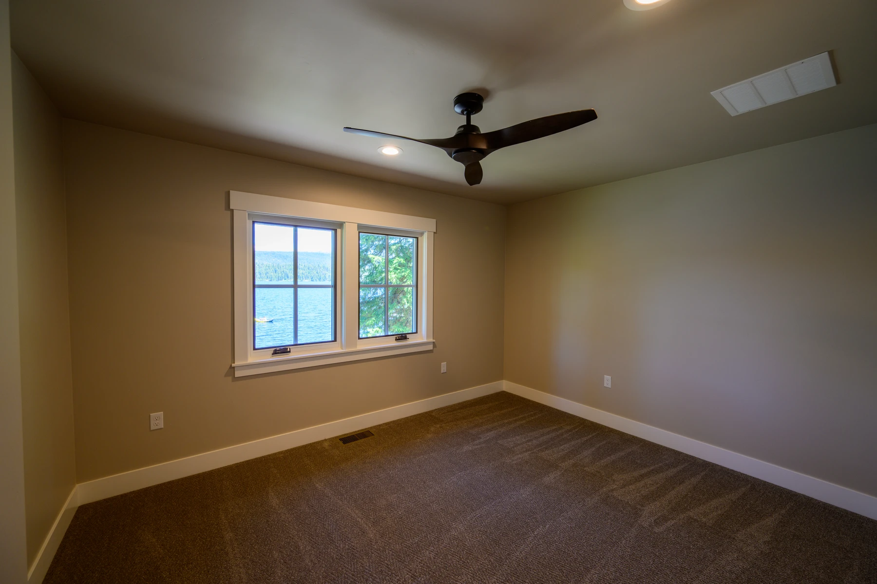 Bedroom with a lake view, ceiling fan, and walk-in closet