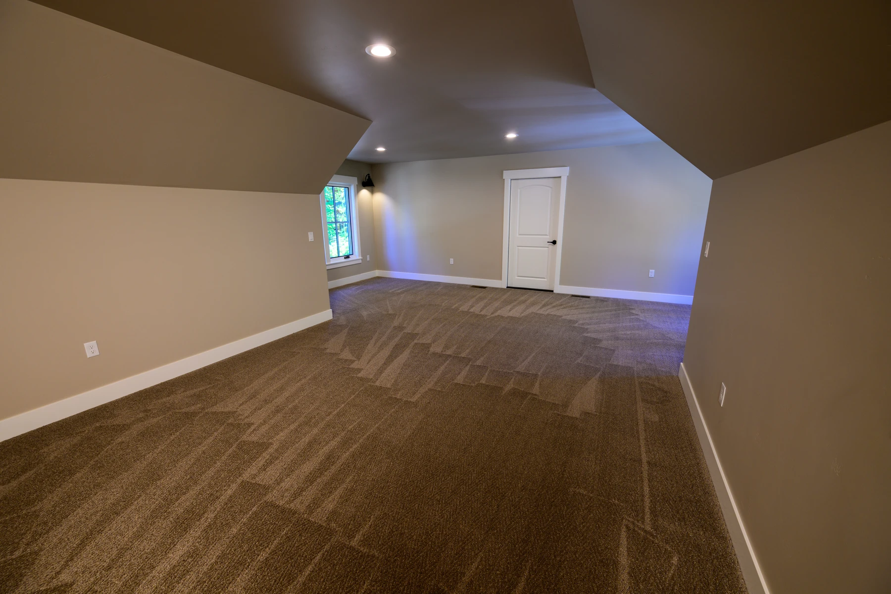 Finished upper flex room with sloped ceilings and plank flooring