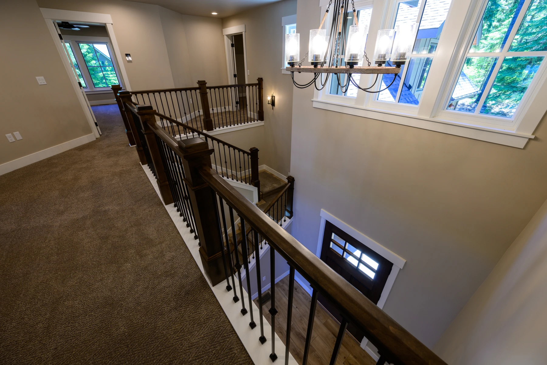 View across the upper landing toward a bank of stairwell windows