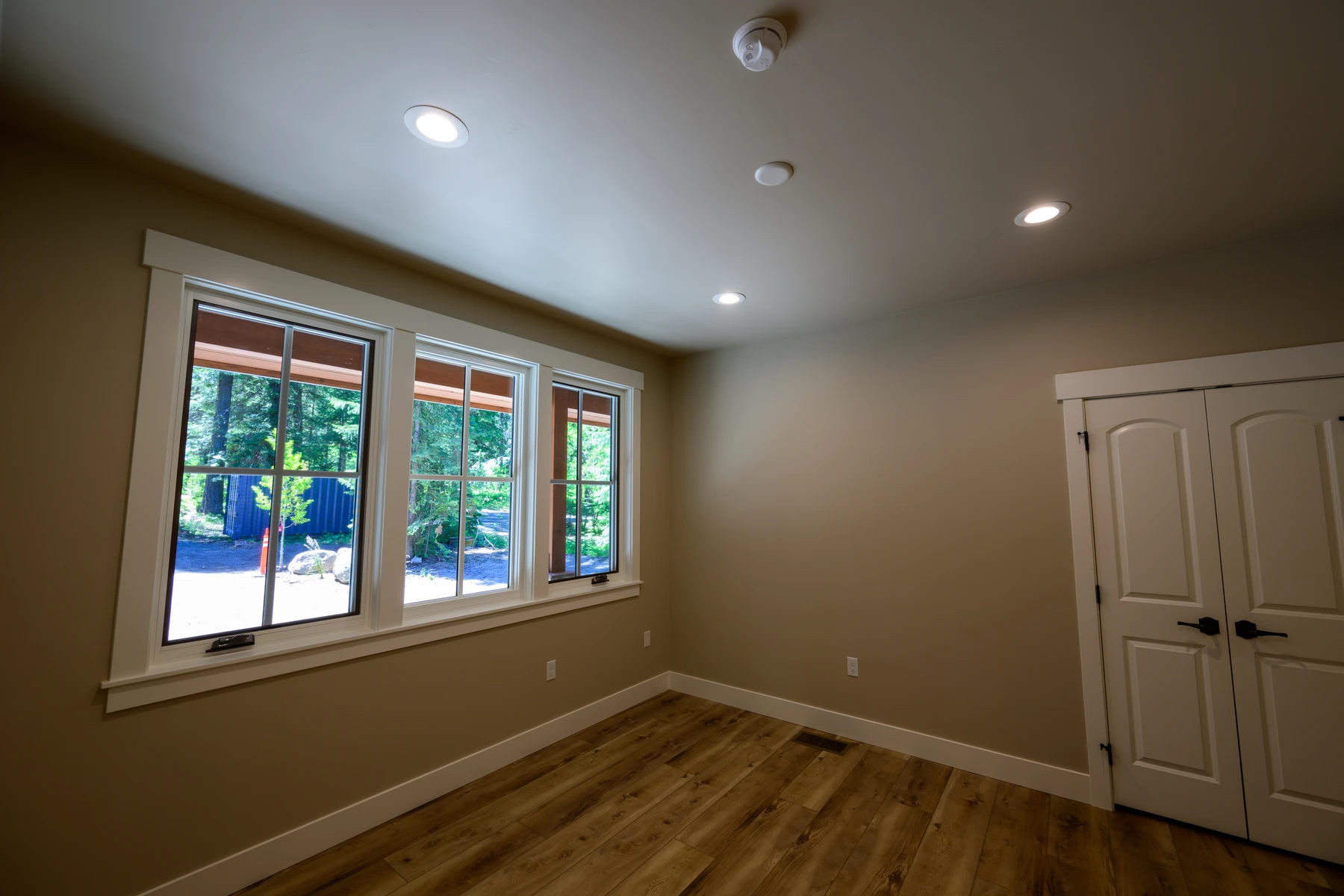 Main-floor flex room with three windows and a double-door closet