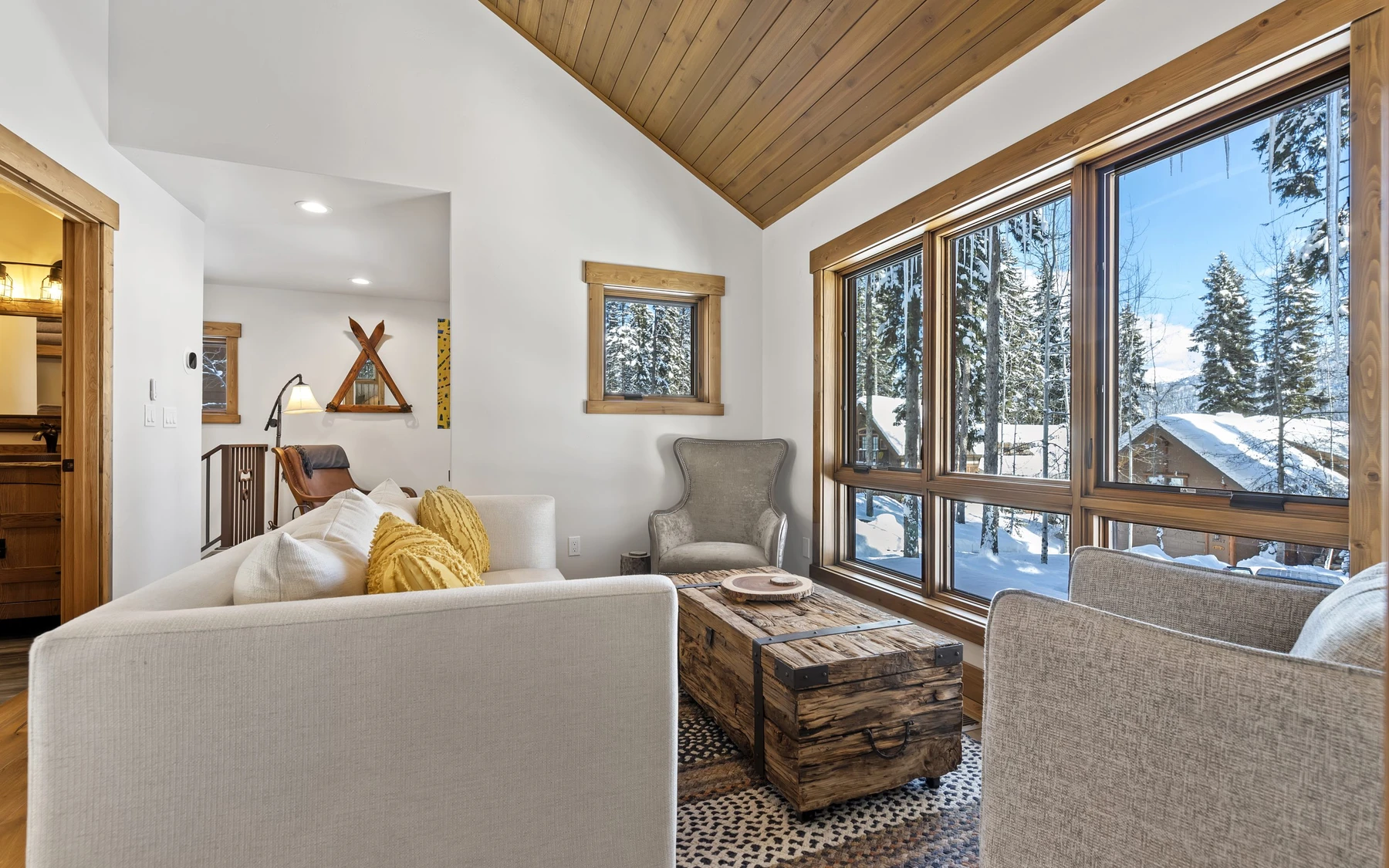 Living room in the Plymouth Retreat mountain home near McCall, with a relaxed seating area, large windows, and warm wood finishes.