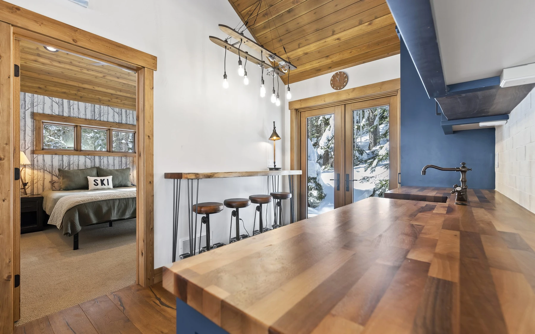 Bedroom in the Plymouth Retreat mountain home near McCall, with a layered bed, large windows, and wood details.