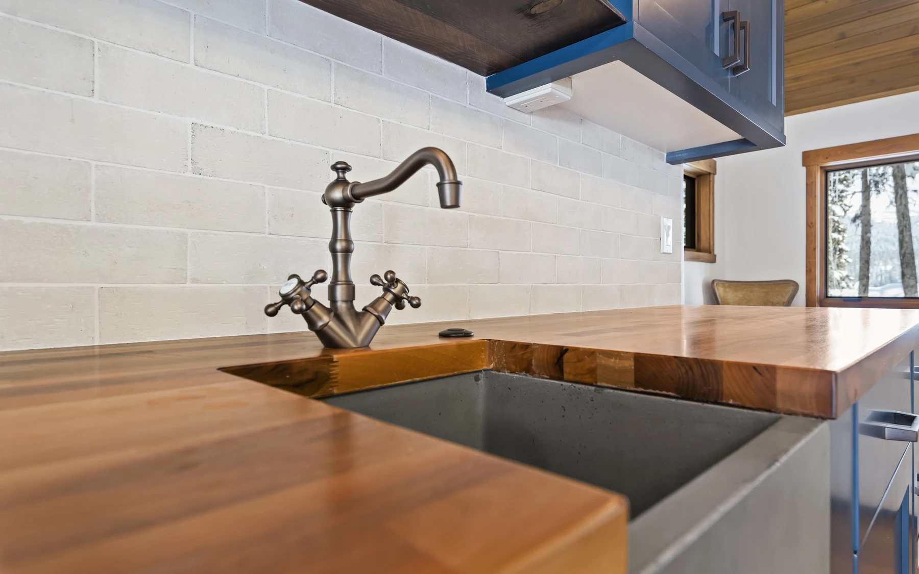 Kitchen in the Plymouth Retreat mountain home near McCall, with wood cabinetry, stone surfaces, and large windows.