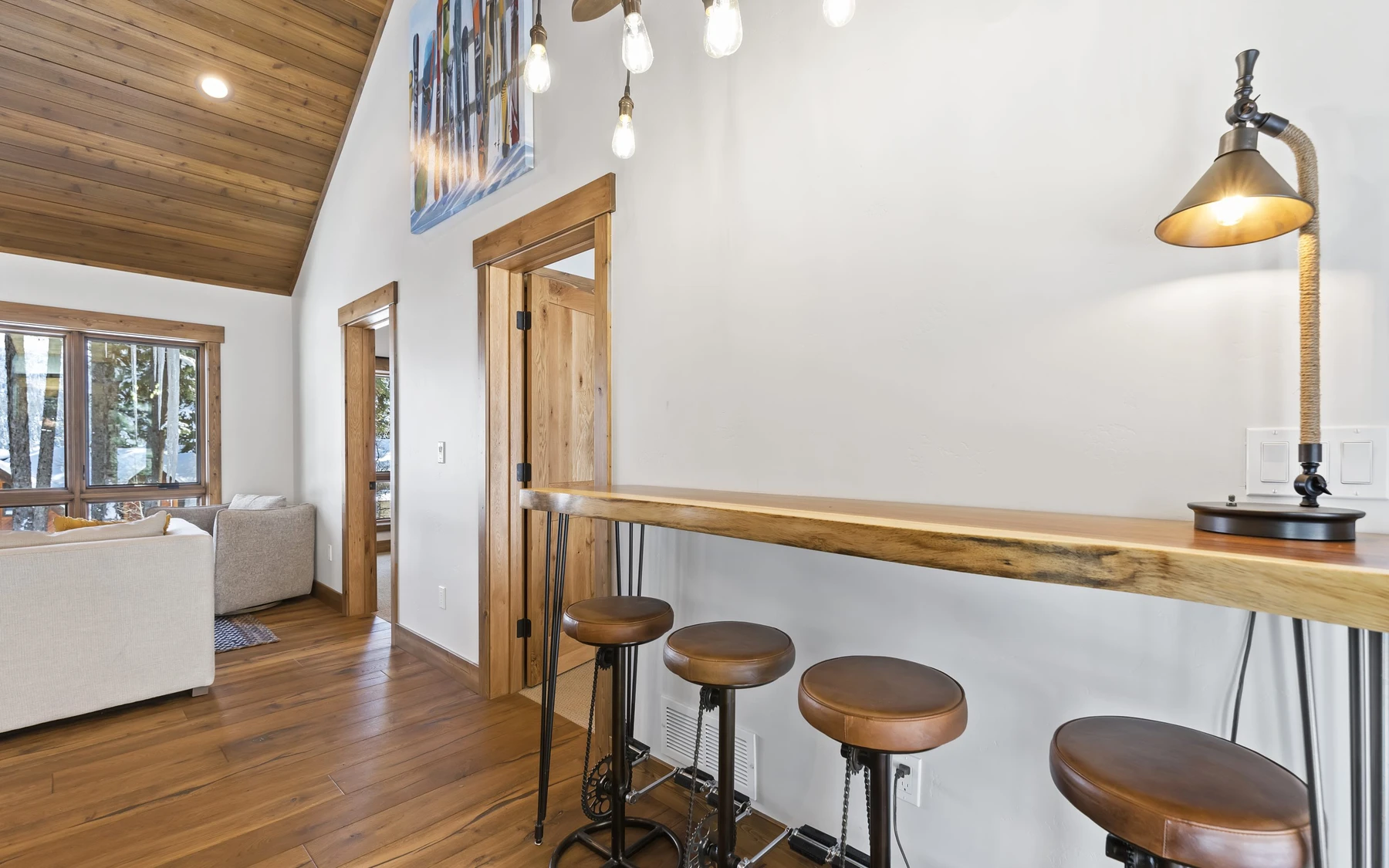 Interior detail in the Plymouth Retreat mountain home near McCall, showing large windows, wood finishes, and decorative lighting.
