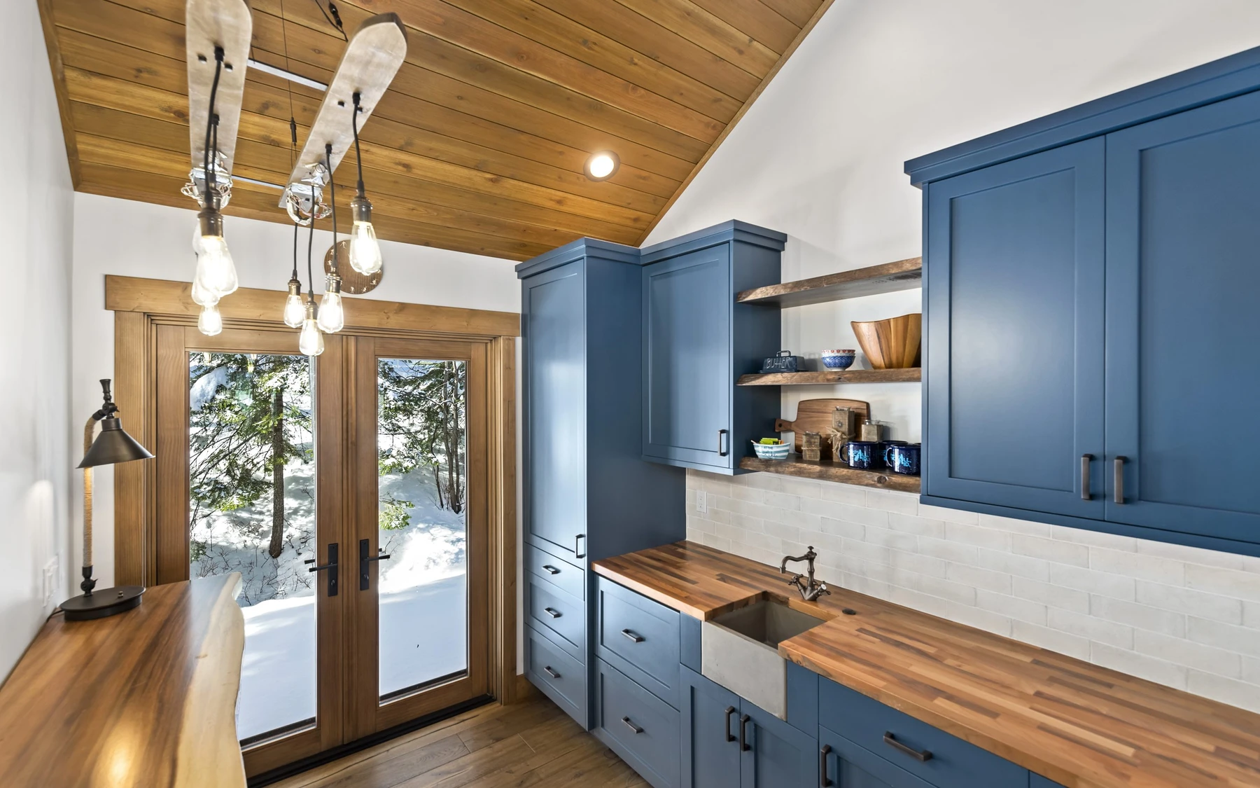 Kitchen in the Plymouth Retreat mountain home near McCall, with wood cabinetry, a broad countertop, and integrated appliances.