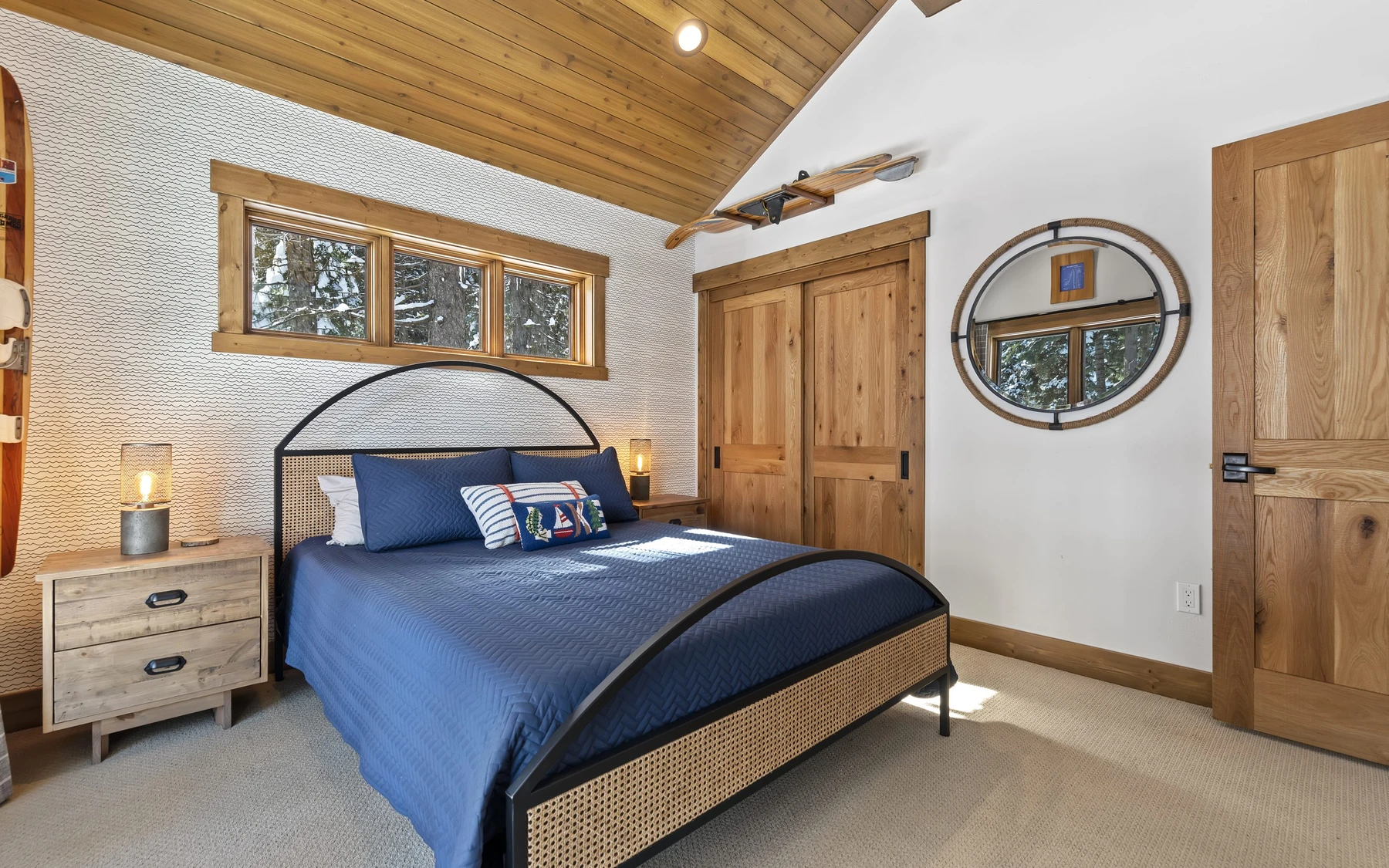 Bedroom in the Plymouth Retreat mountain home near McCall, with a layered bed and wood details.